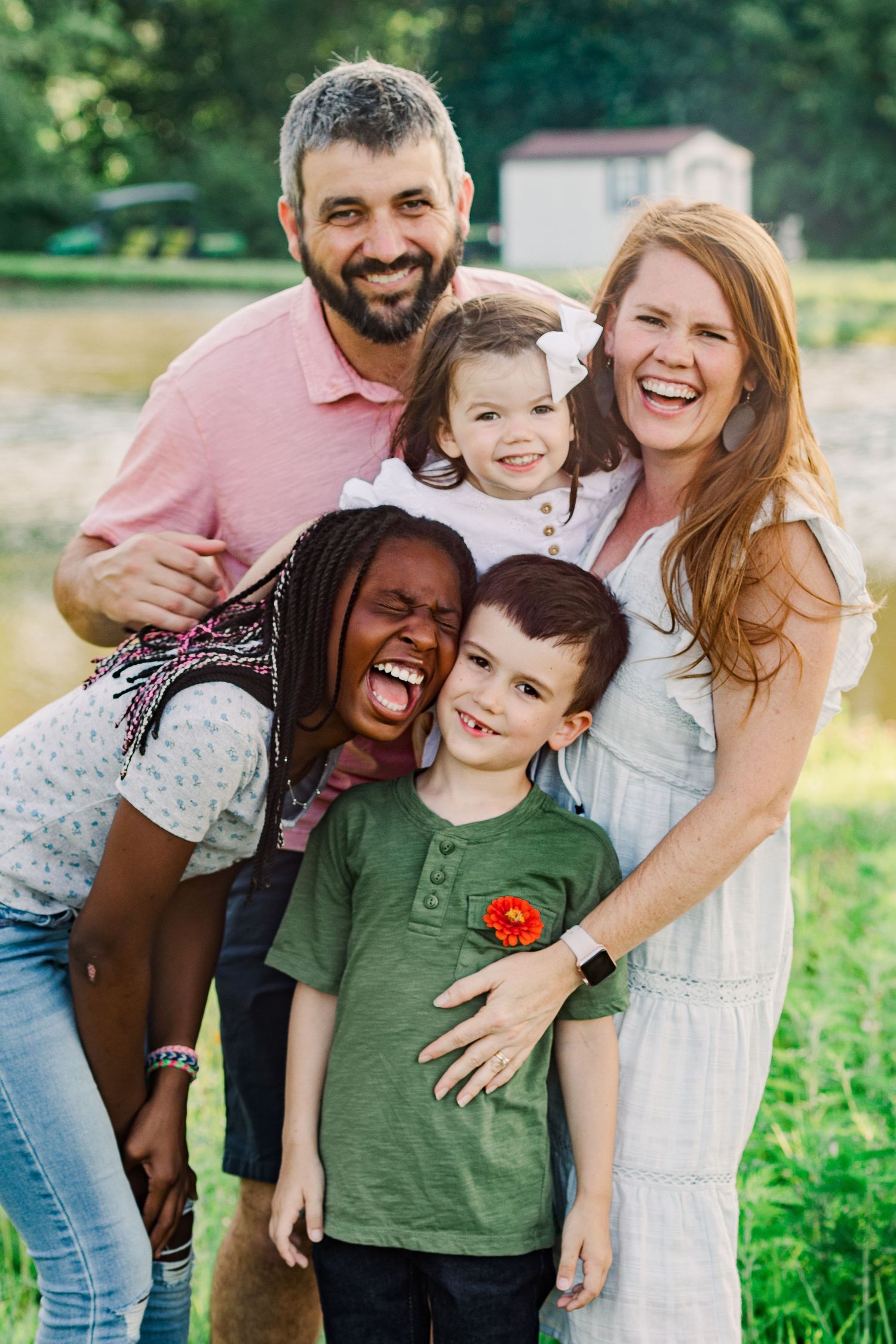 Joyful family laughing together during outdoor photo session.