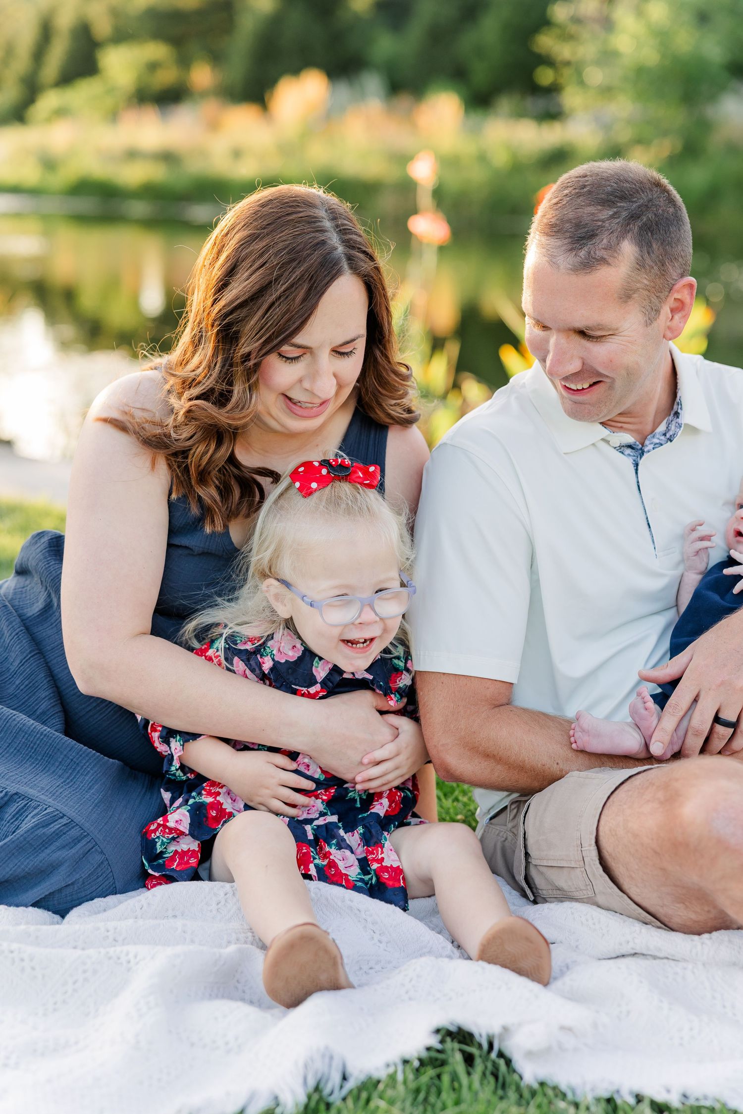 Hilary and Andrew smiling with Caroline and baby Lincoln during their family-of-four portraits.