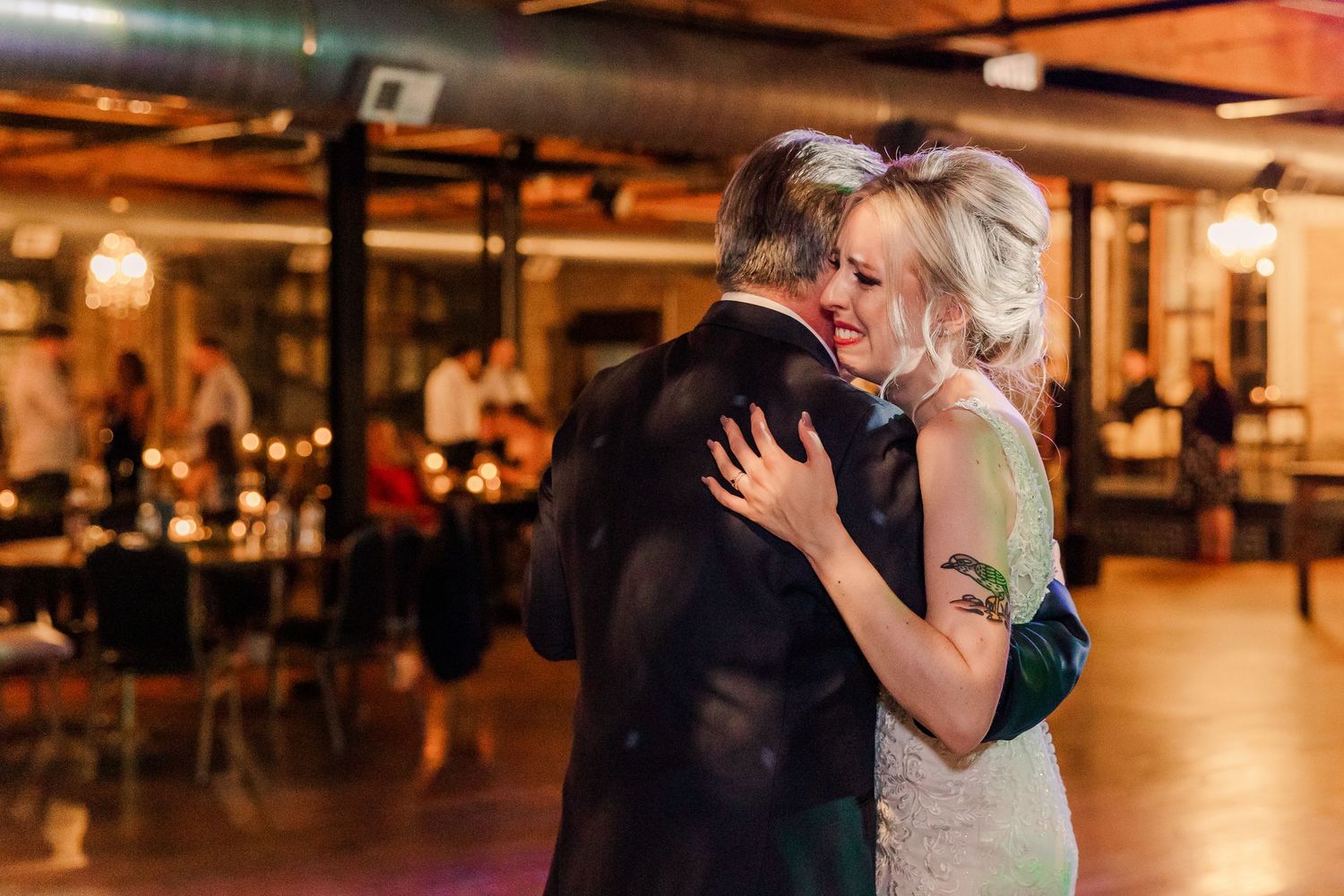 An intimate dance moment captured in warm lighting at an indoor wedding reception.