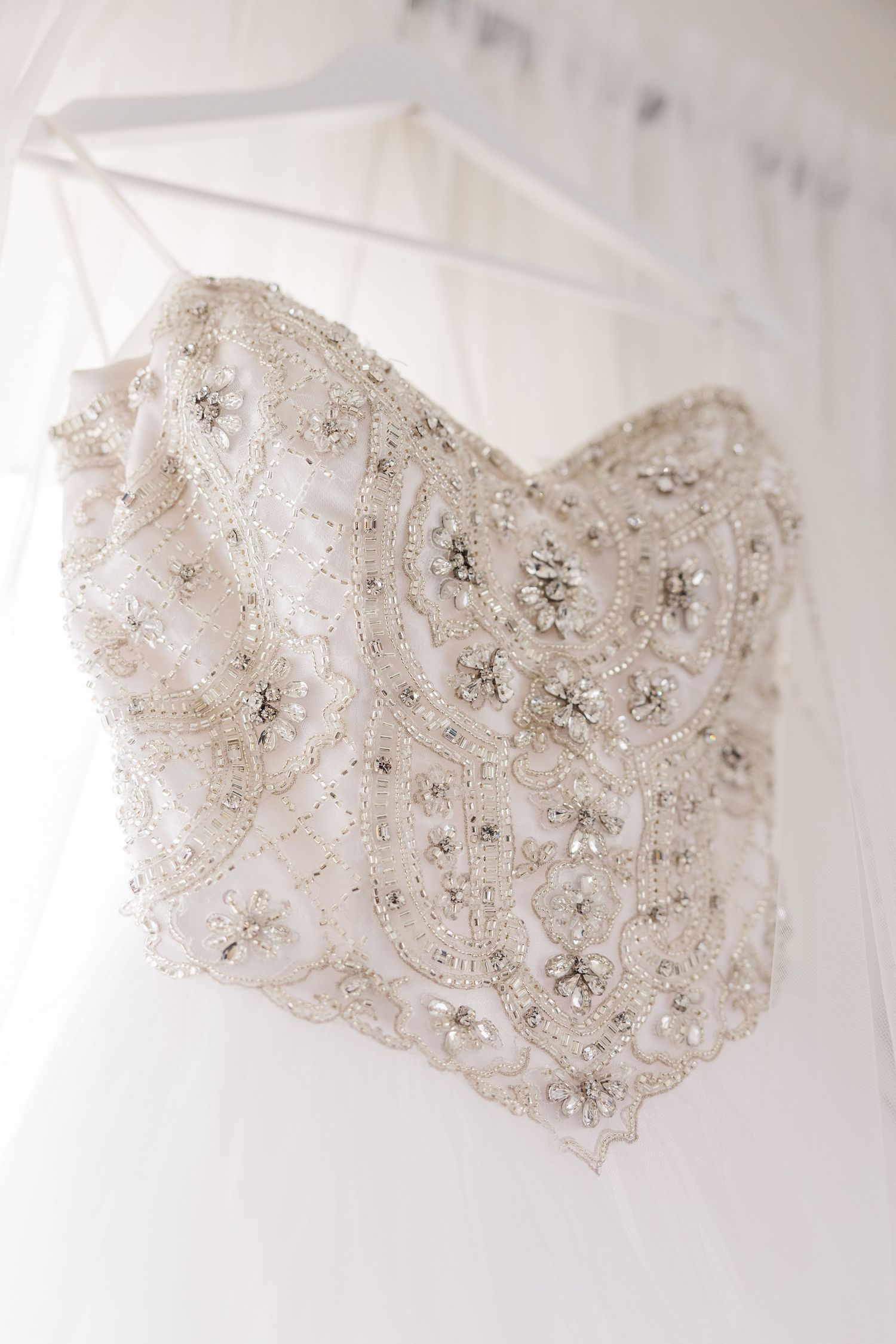 Close-up of intricate beaded bodice detail on a white wedding gown.