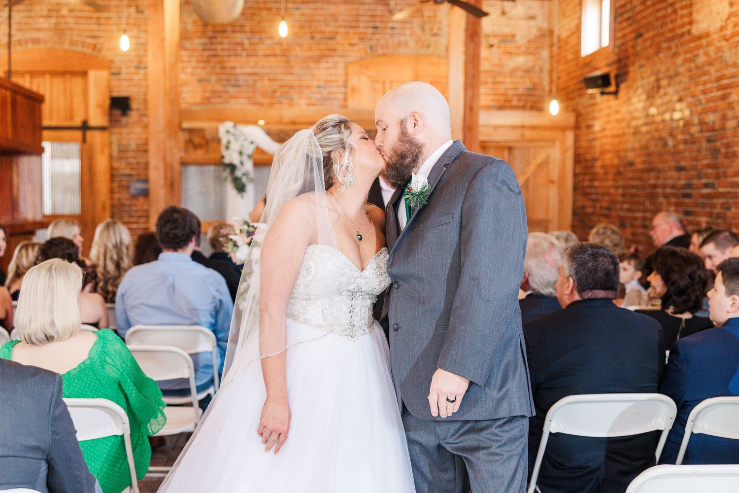 A joyful wedding celebration moment inside a rustic brick venue with string lights.