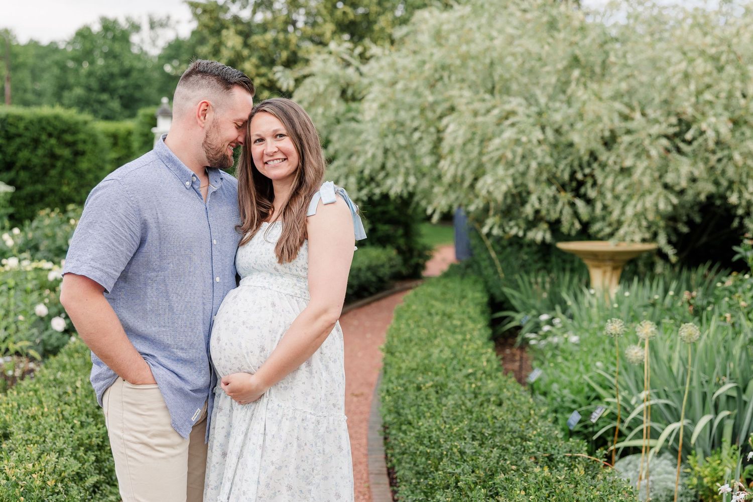Expecting parents cuddling together in the gardens during a Cantigny Park maternity session