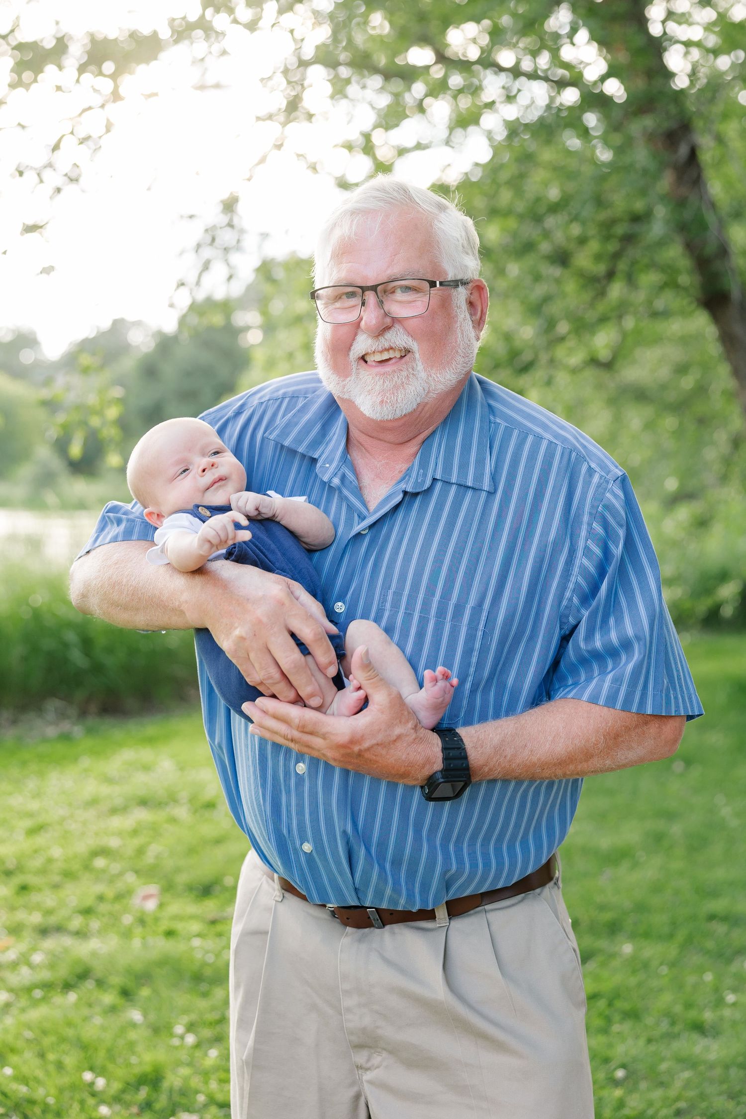Grandfather holding his baby grandson during an extended family portrait session at Veterans Acres Nature Center in Crystal Lake