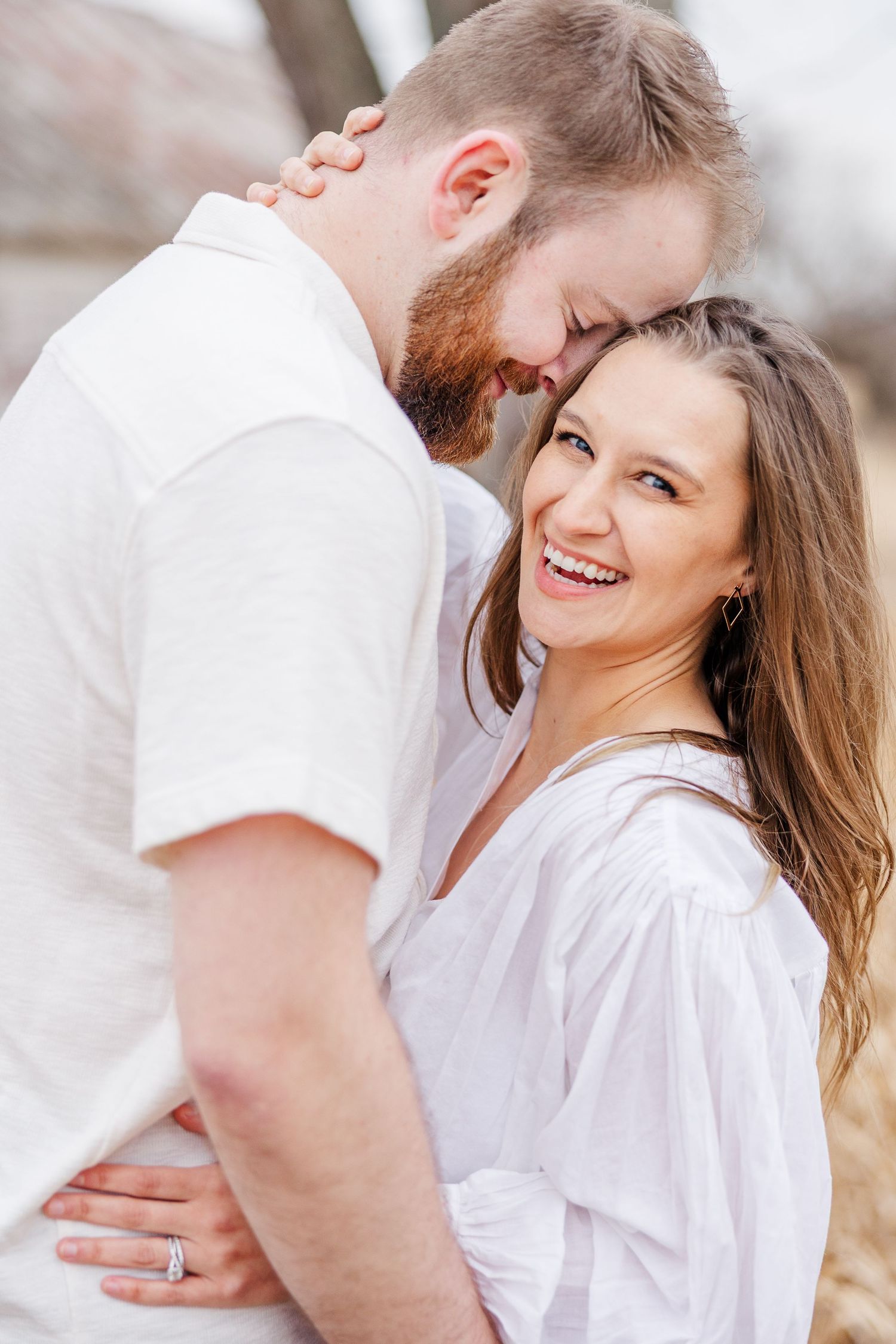 Couple embracing during pregnancy announcement photos in Cary, Illinois
