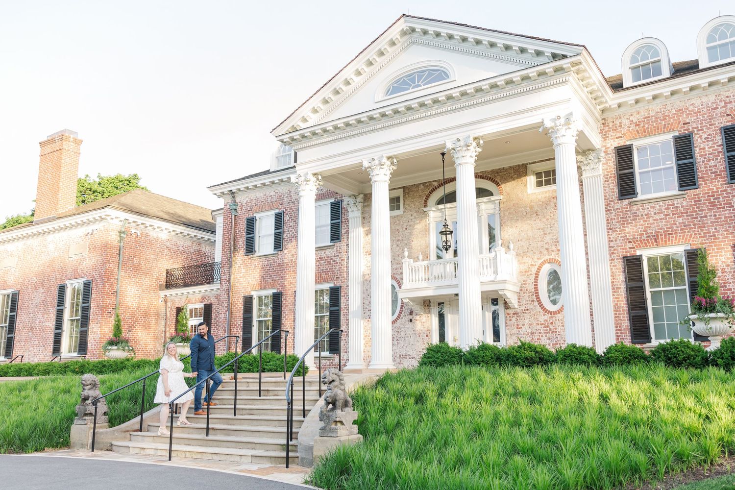 Southern colonial style mansion with white pillared portico and manicured lawn.