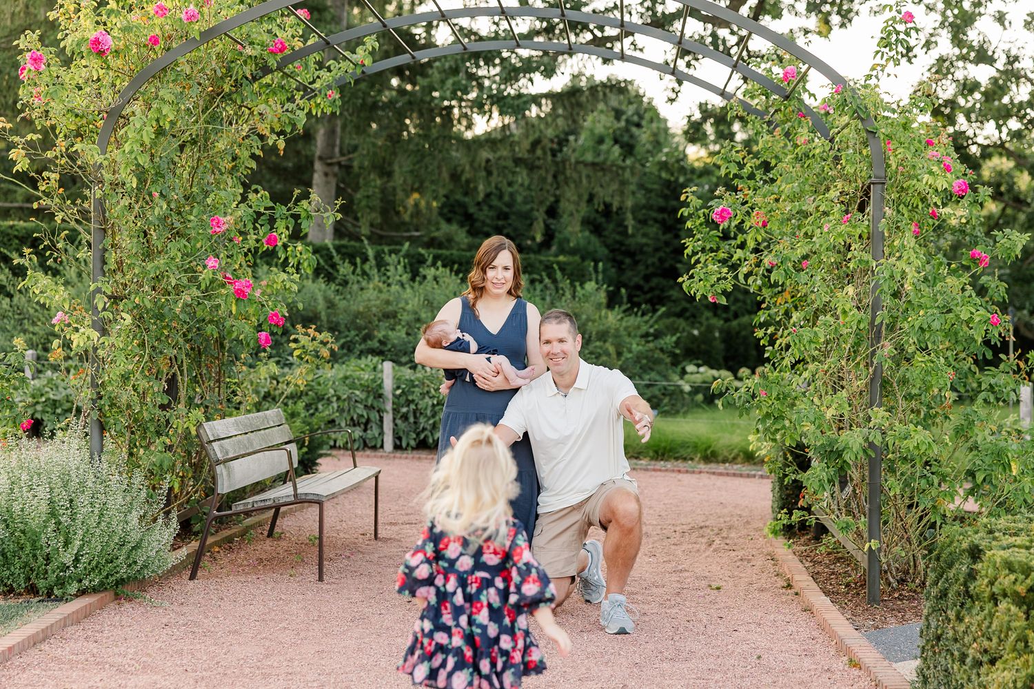 The Lawler family playing together beneath a flower-covered arch in the Cantigny Park gardens.