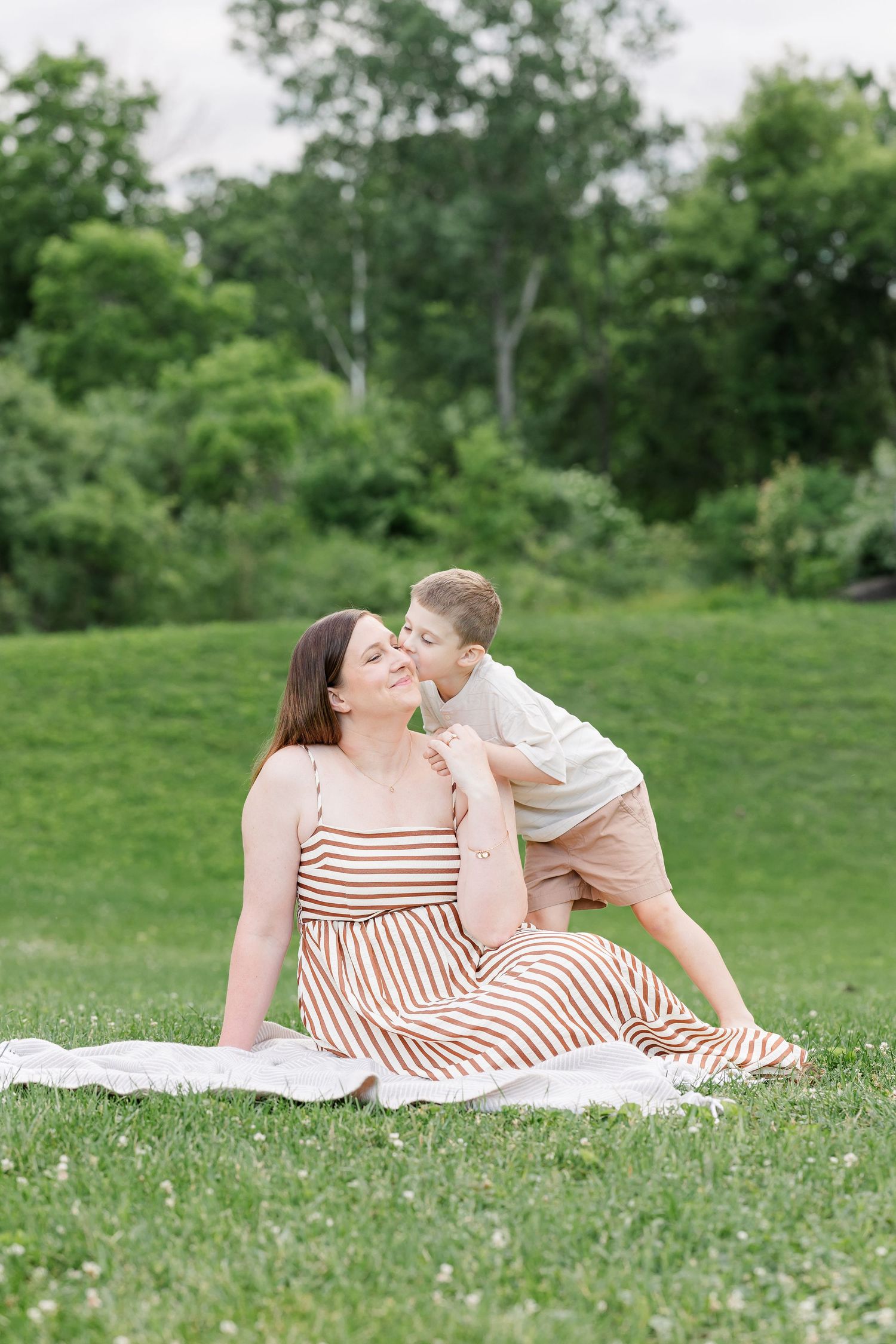 Mom snuggling her son on a blanket during a sweet summer family portrait session in Crystal Lake.