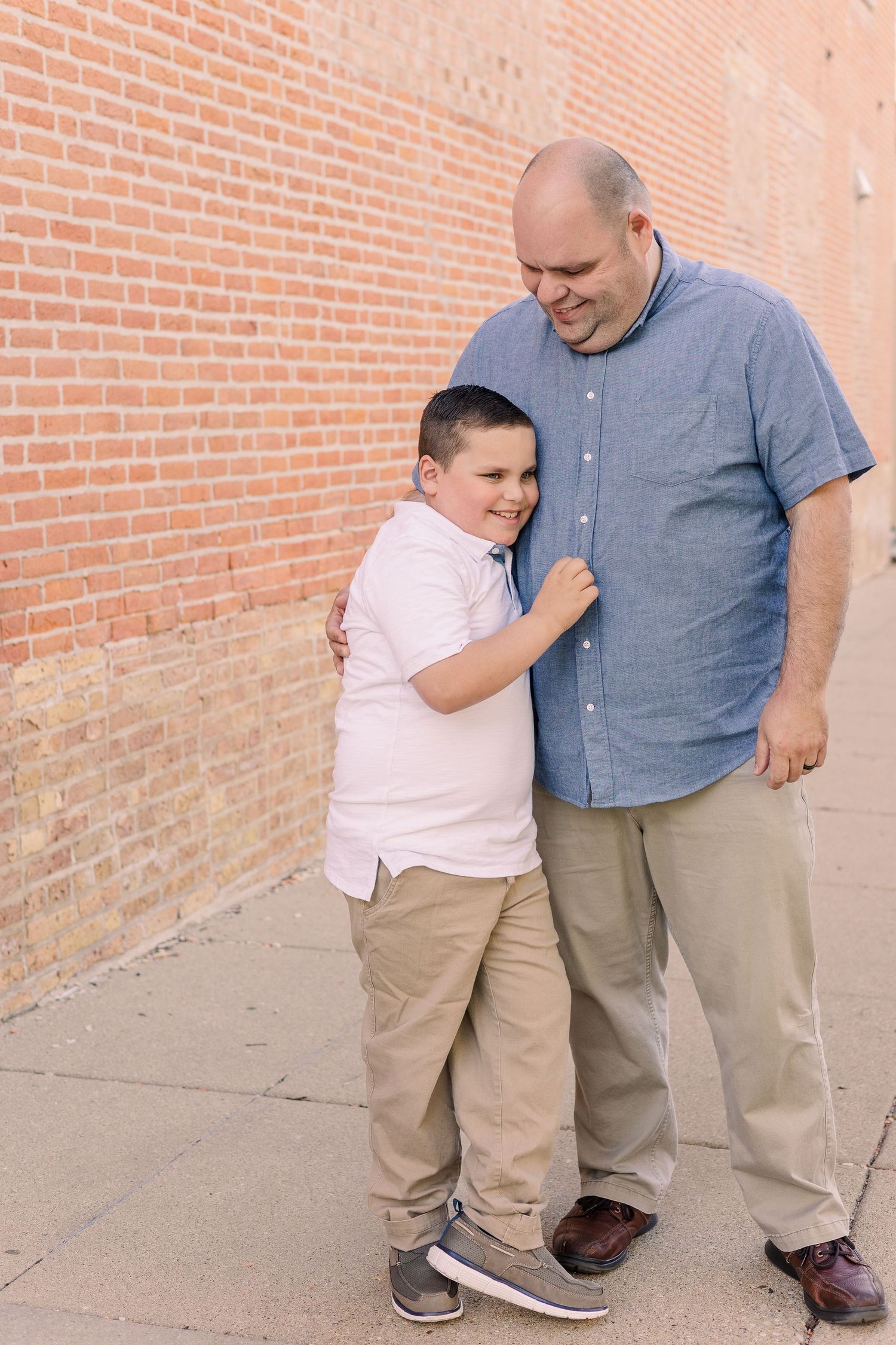 A touching moment shared between two people against an urban brick backdrop.