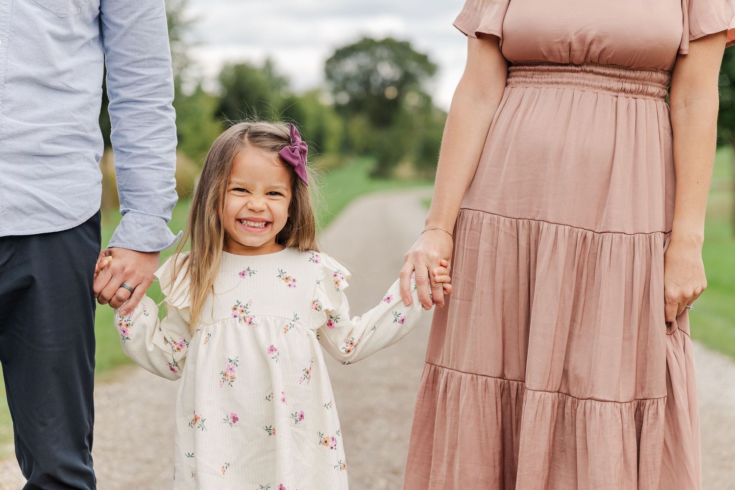 A candid moment on a dirt path showing hands joined together while walking.