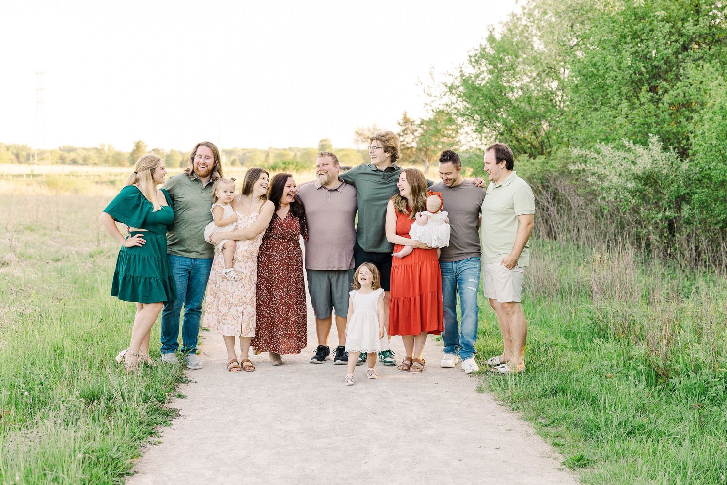 Group photo of people wearing colorful outfits posing together on a nature path.
