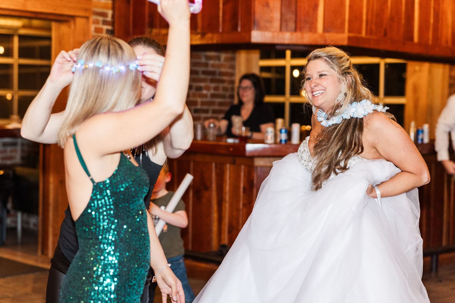 Wedding guests dancing and celebrating in a rustic brick venue.
