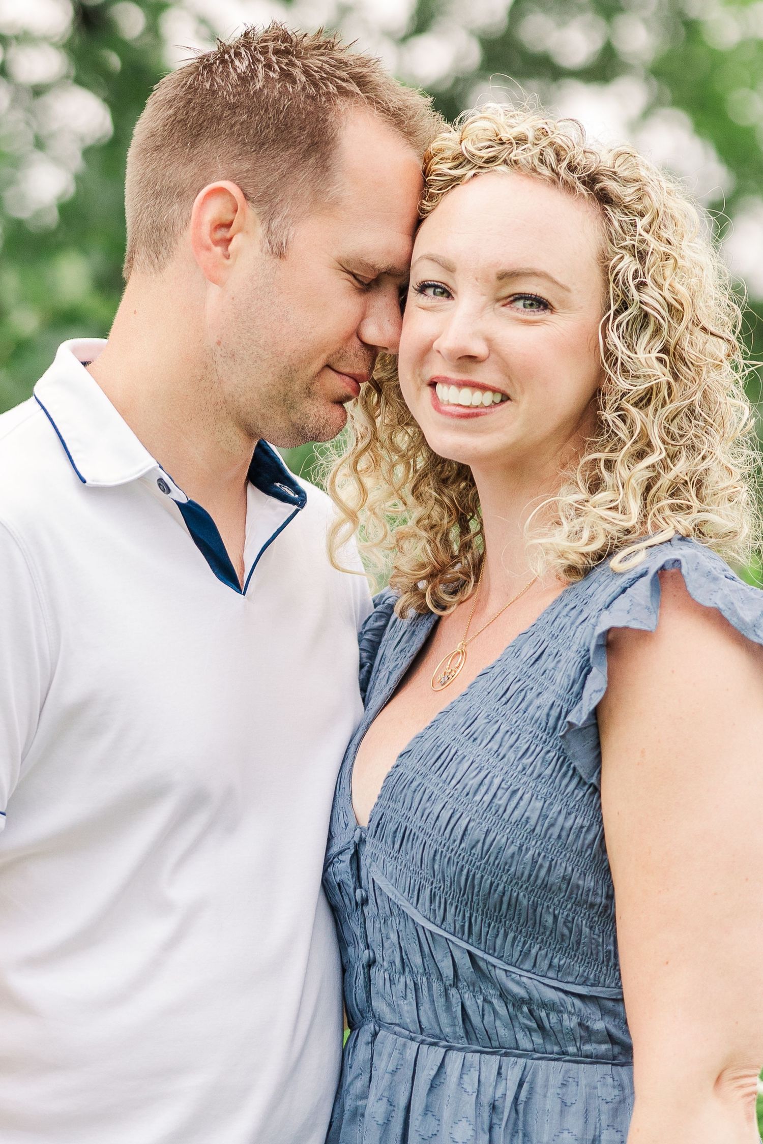 A romantic close-up portrait of a couple sharing an intimate moment outdoors.