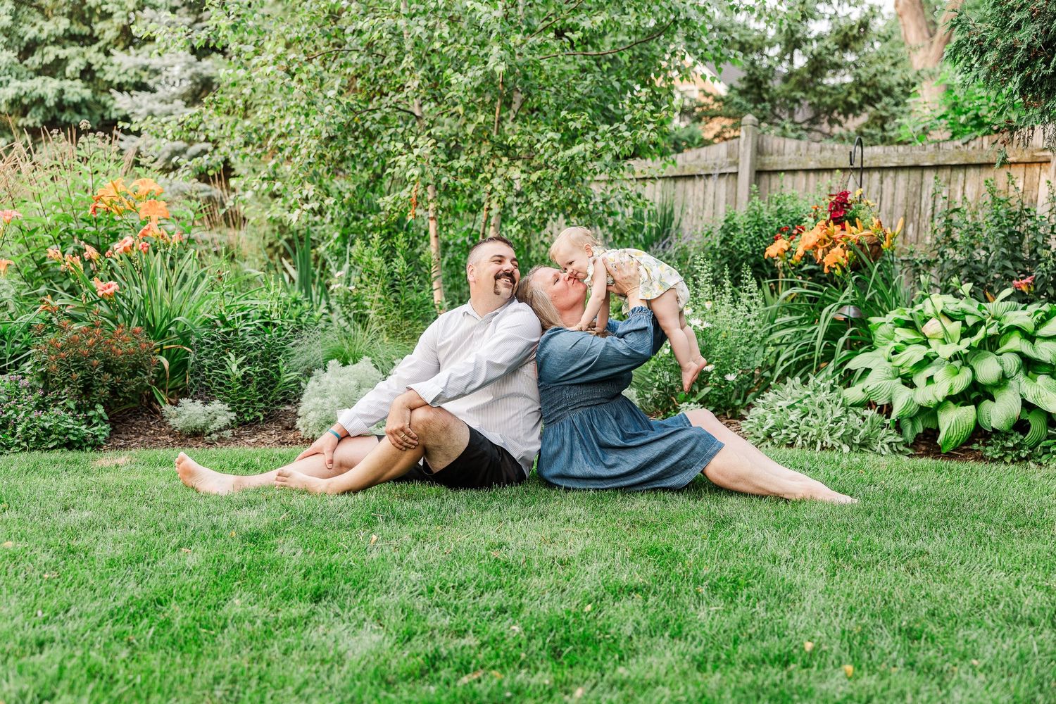 Relaxed couple lounging on green grass in a beautiful summer garden setting.