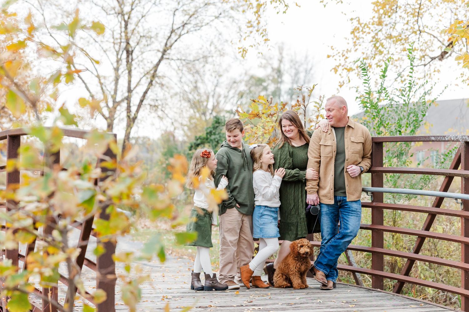 Family fall mini session at Jaycee Park in Cary, Illinois with parents, children, and dog on bridge