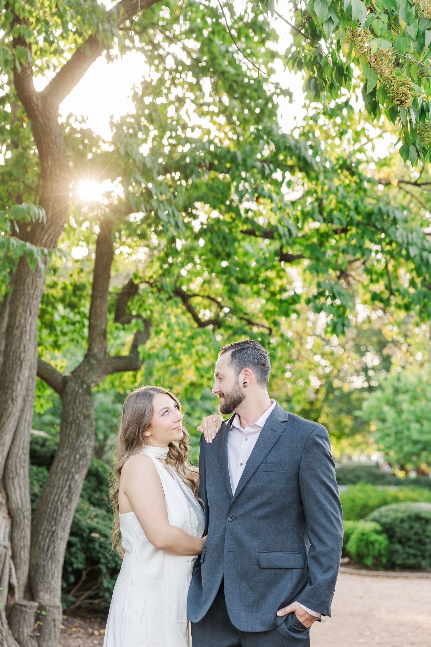 Couple standing beneath trees during engagement photos at Cantigny Park in Wheaton, Illinois