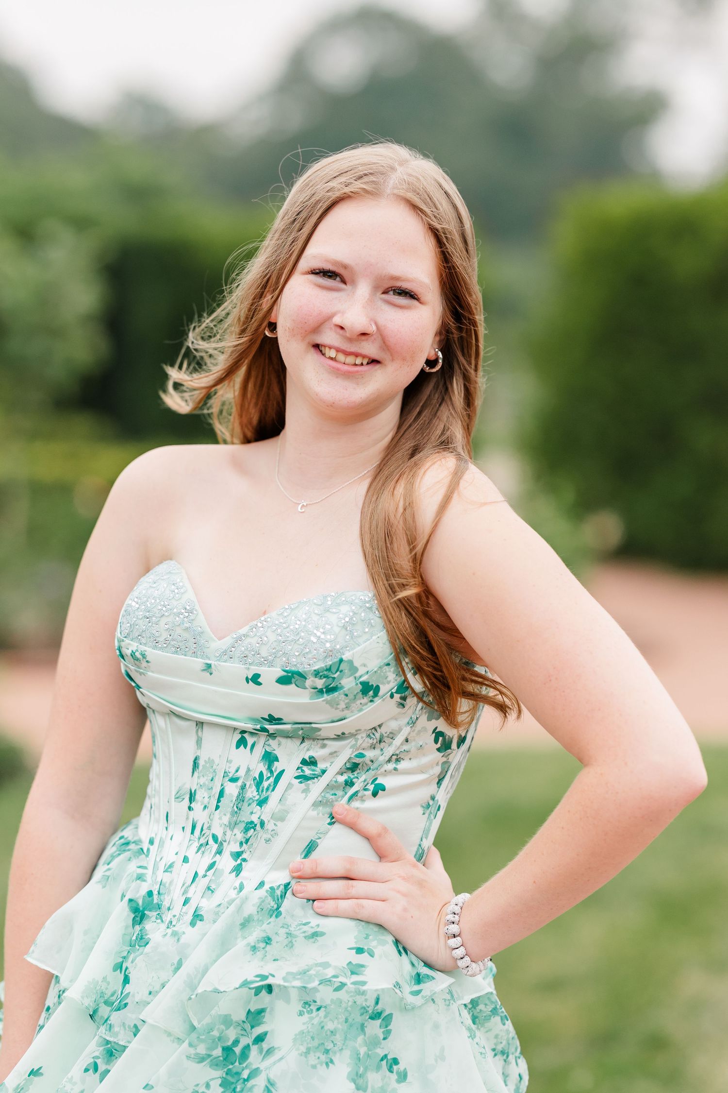 Samantha smiles in a mint floral dress during her senior portraits at Cantigny Park in Wheaton, Illinois.