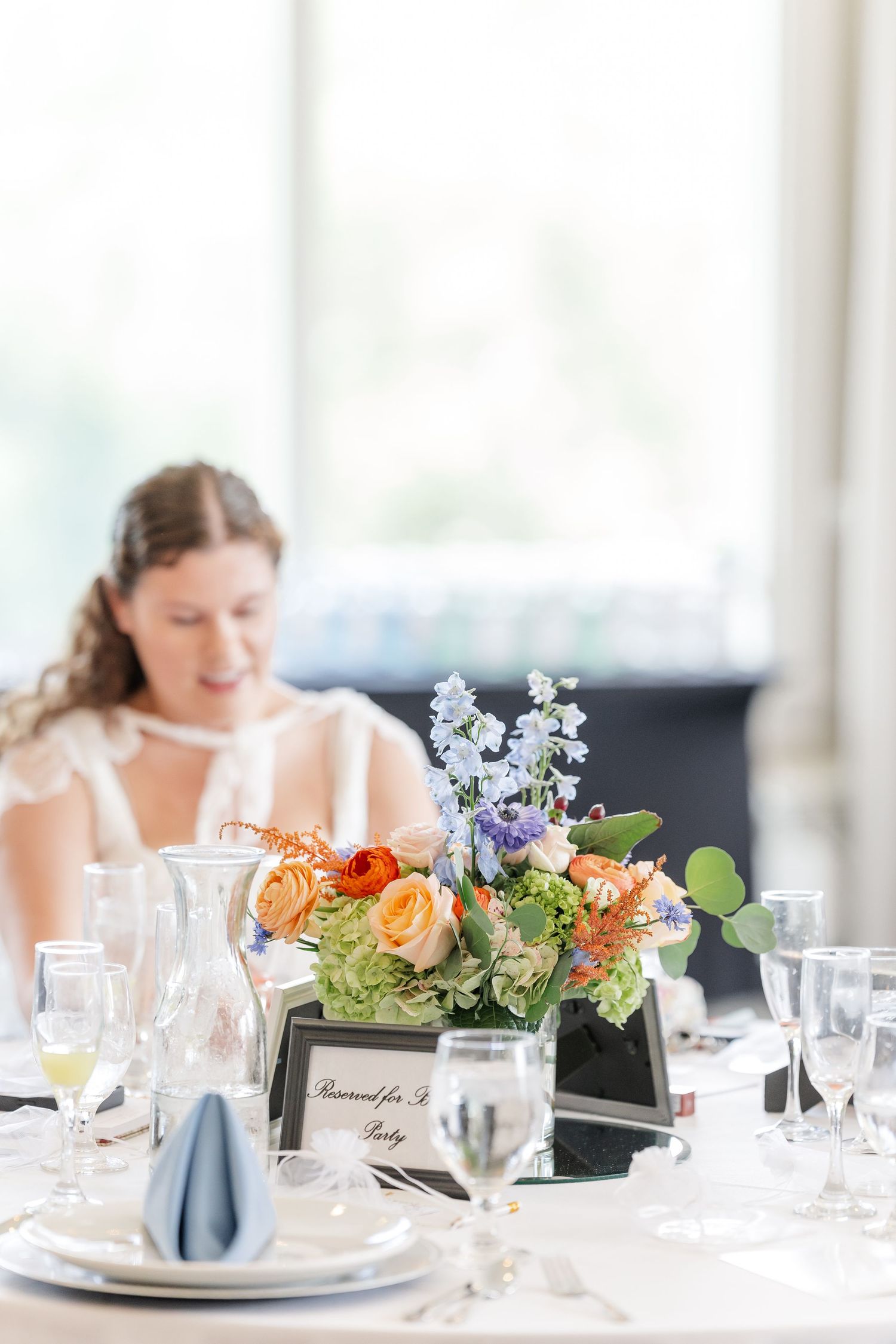 Sarah seated at floral centerpiece table during her bridal shower