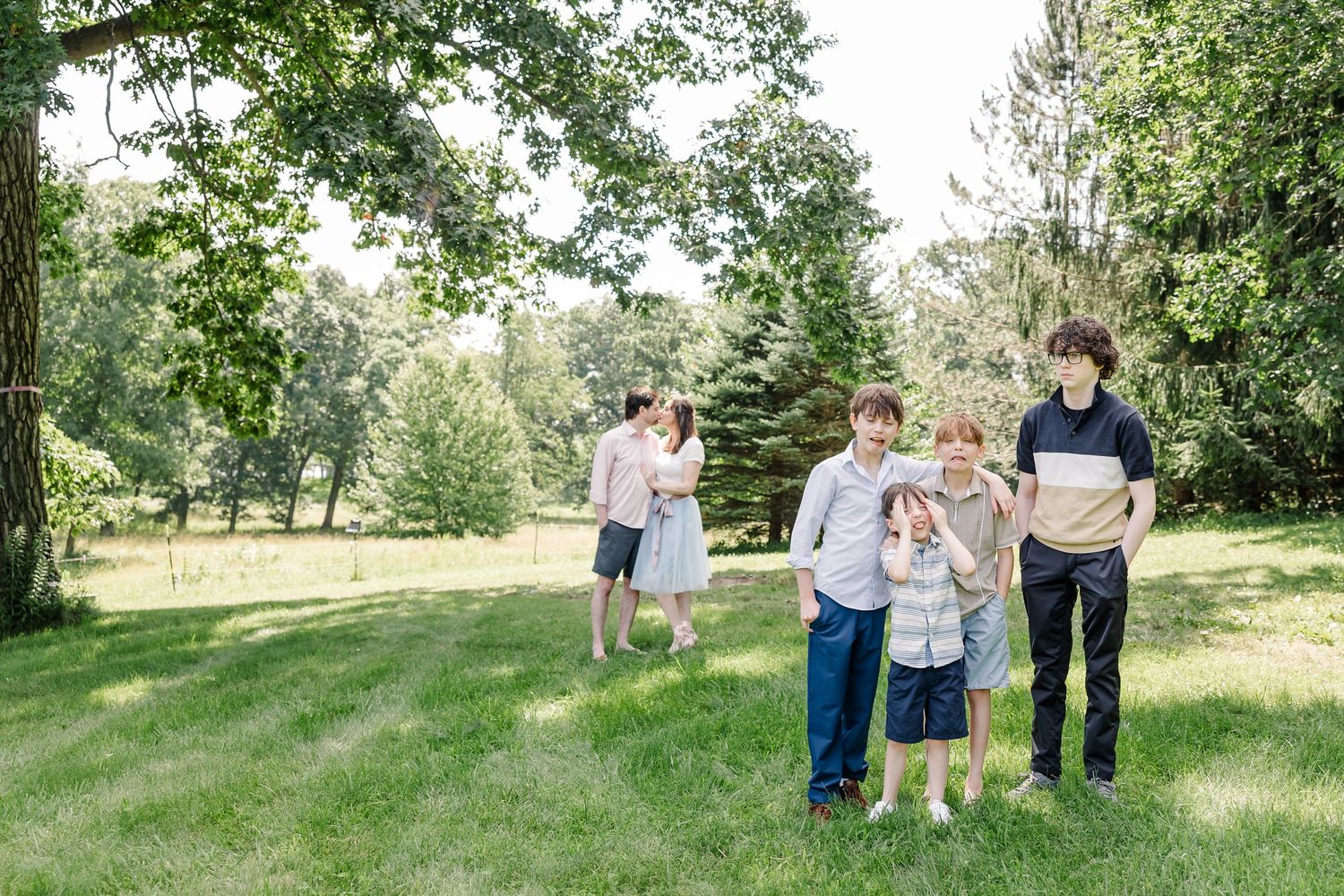 Extended family walking together through the yard during a relaxed summer family reunion session in Crystal Lake, Illinois.