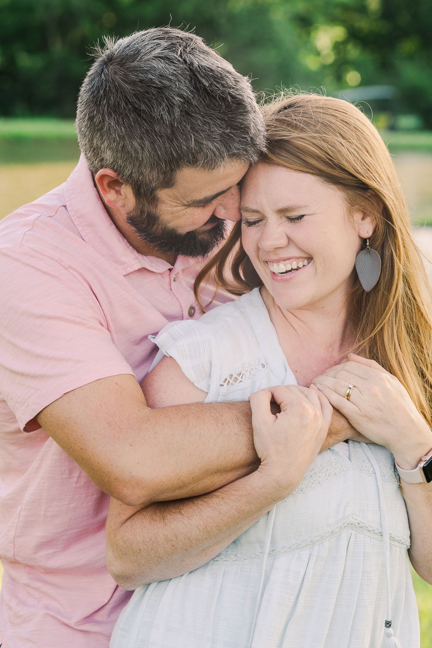 Intimate moment between couple embracing outdoors in natural lighting.