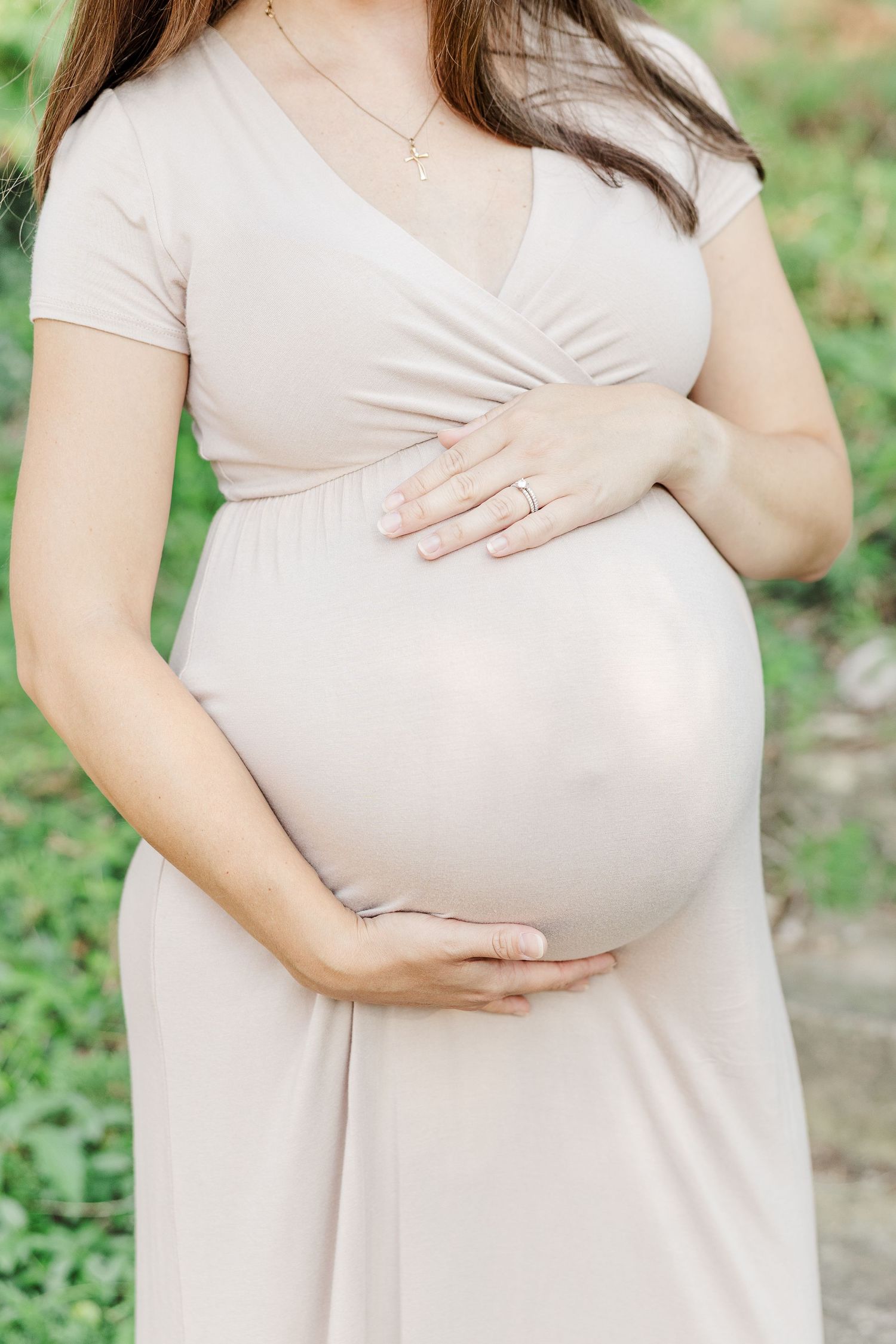 Maternity detail of pregnant mother holding baby bump in neutral dress during outdoor session at Shamrock Hills Park Crystal Lake IL
