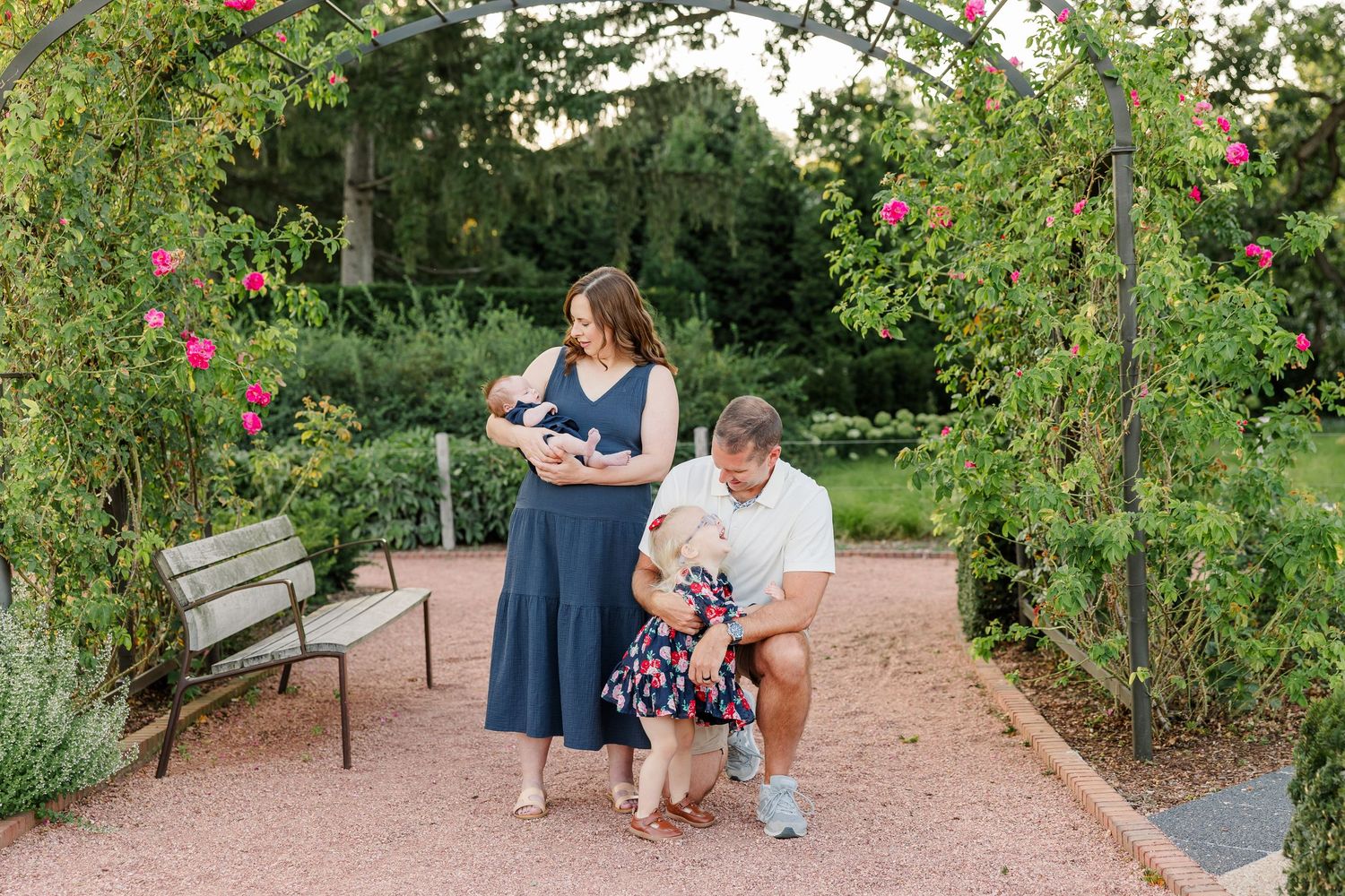 Hilary and Andrew laughing with Caroline as they hold baby Lincoln in the garden.