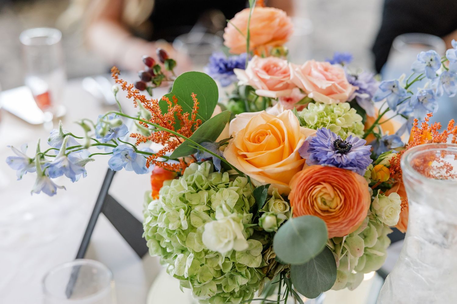 Orange rose and blue delphinium centerpiece at wildflower bridal shower
