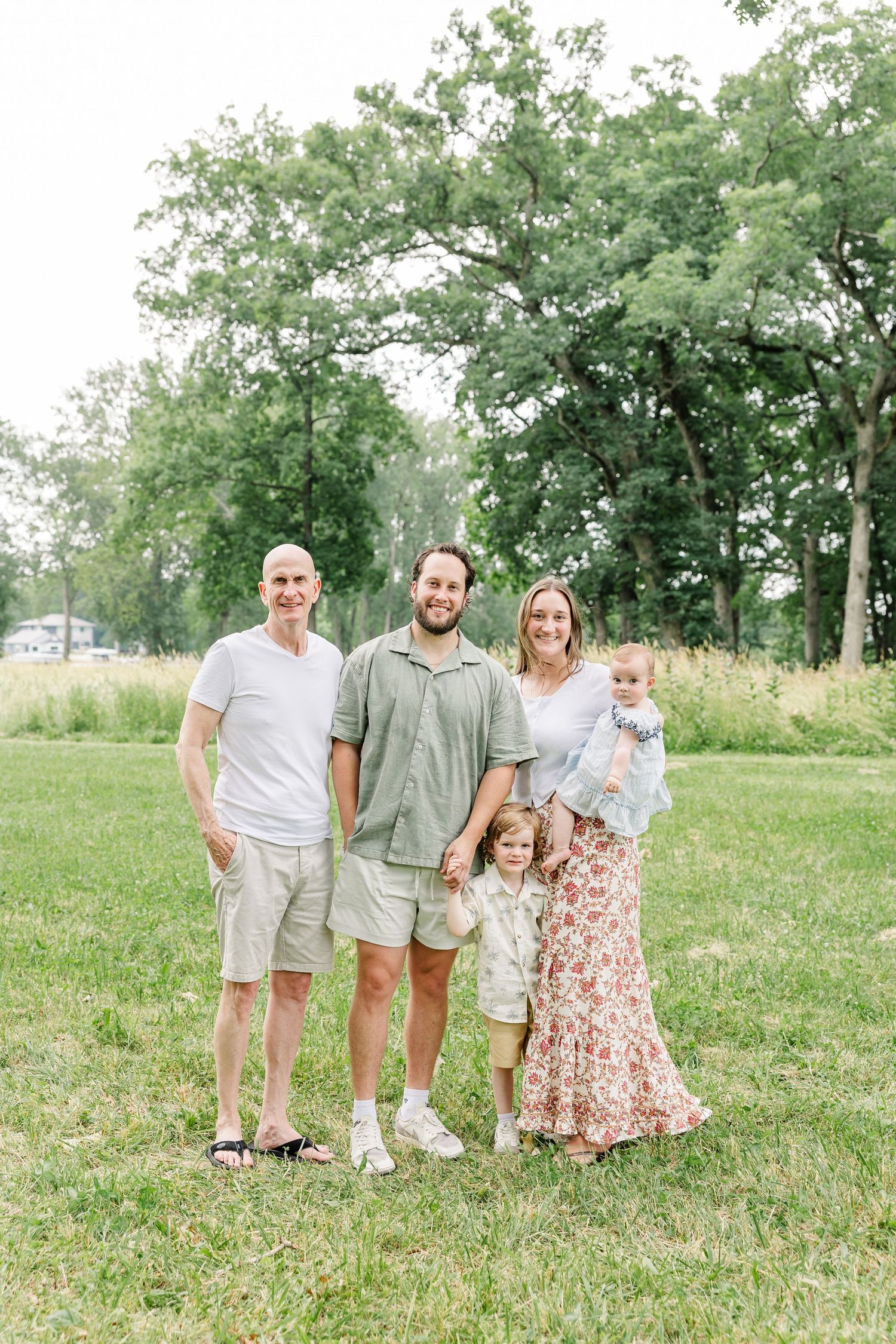 Family of four standing together outdoors during a summer family portrait session in Crystal Lake, IL.