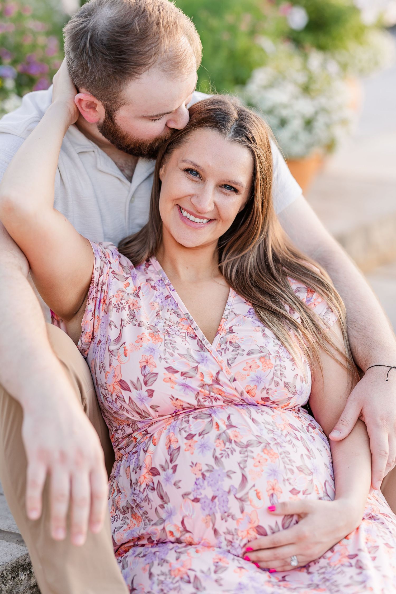 Expecting parents cuddling on garden steps during a romantic Cantigny maternity session in Wheaton Illinois