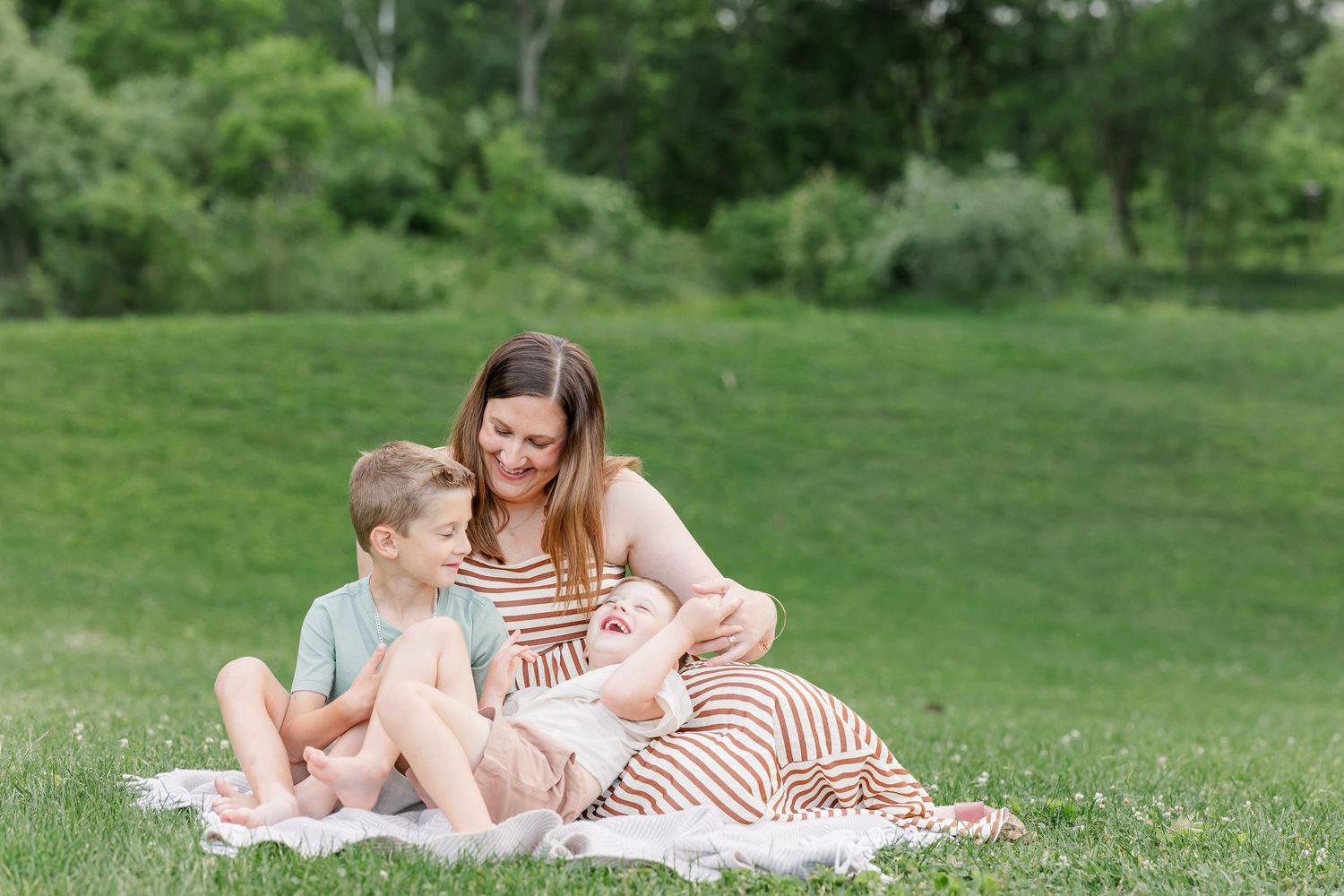 Mom sitting with her two sons during a relaxed summer family photography session in Crystal Lake.