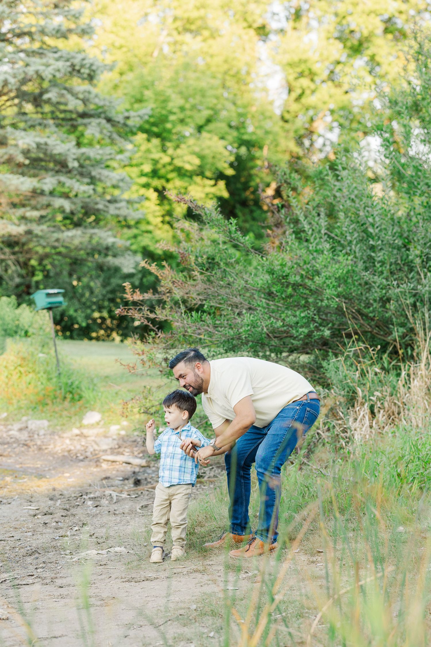 Two figures explore a grassy hillside path together during a golden autumn afternoon.Sorg family portraits at Shamrock Hills Park in Crystal