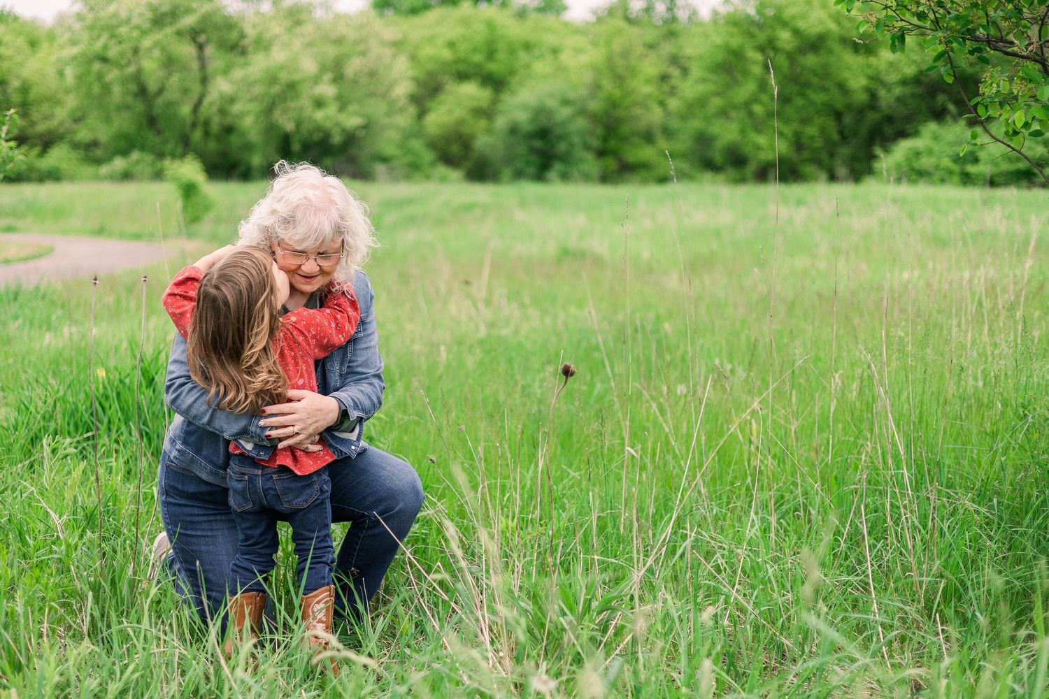 Tender embrace shared between two people in a lush green meadow.