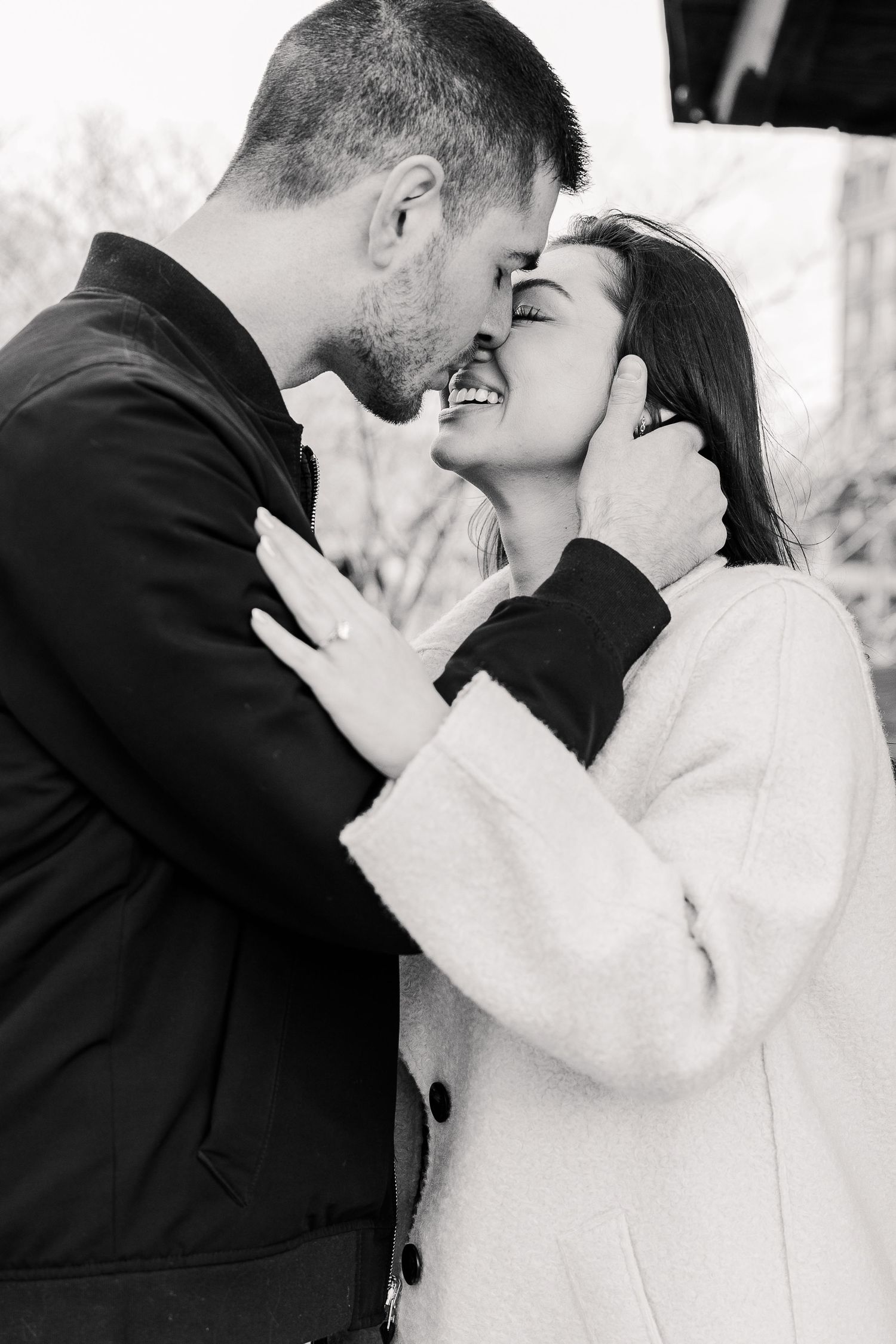 A black and white portrait of a couple sharing an intimate moment while embracing.