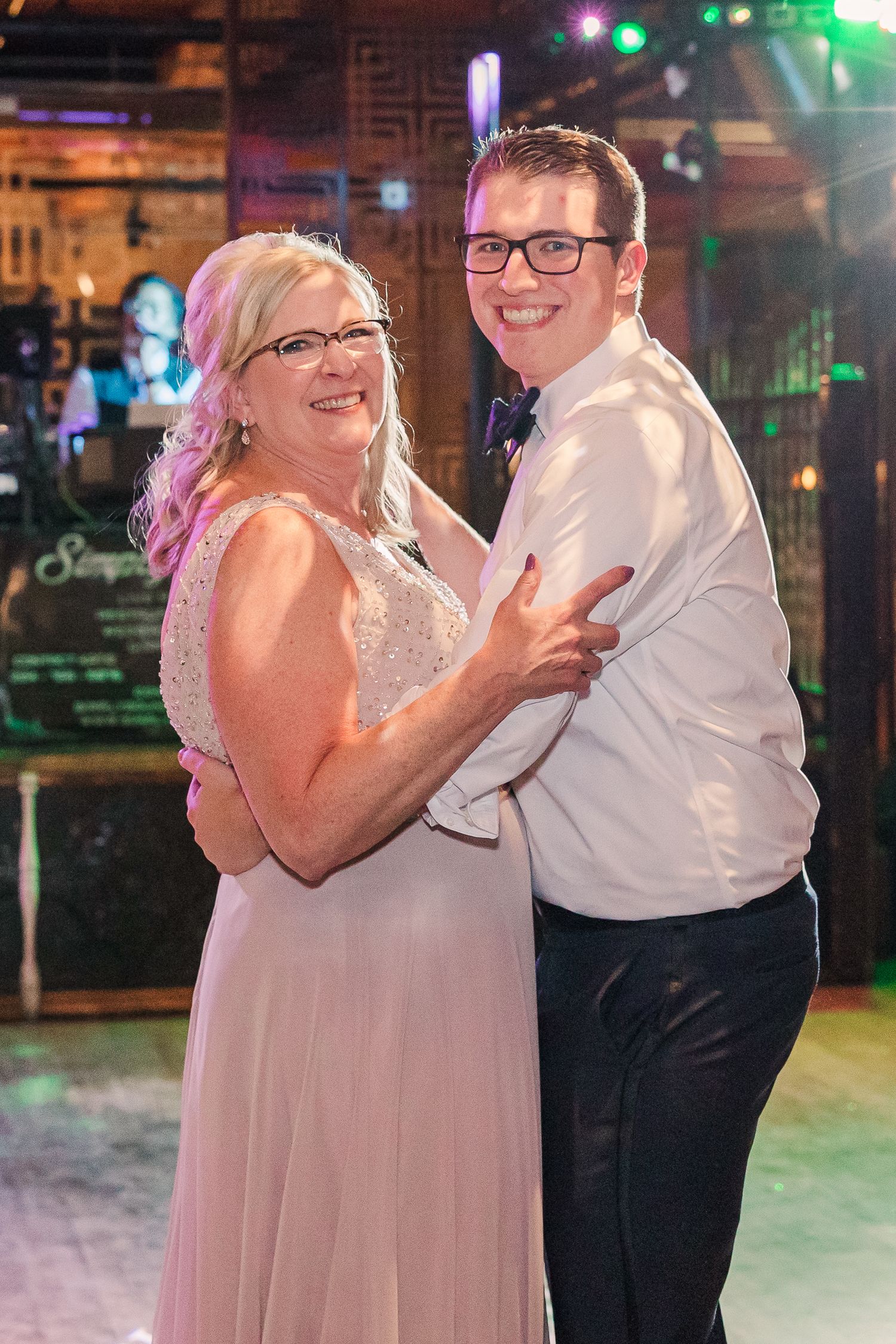 A couple shares a joyful moment while dancing at their celebration.
