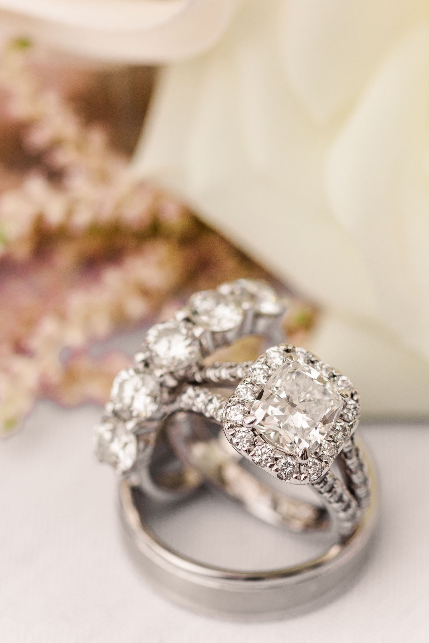 Elegant diamond engagement ring and wedding band set displayed on a soft white background.