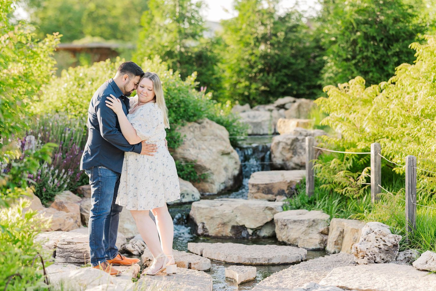 A romantic moment shared by a couple near a cascading garden waterfall feature.