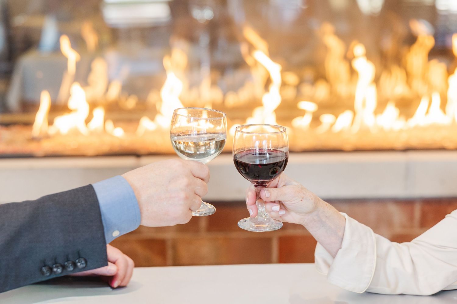 Beacon Hill senior living branding photo in Lombard, Illinois featuring wine glasses by fireplace