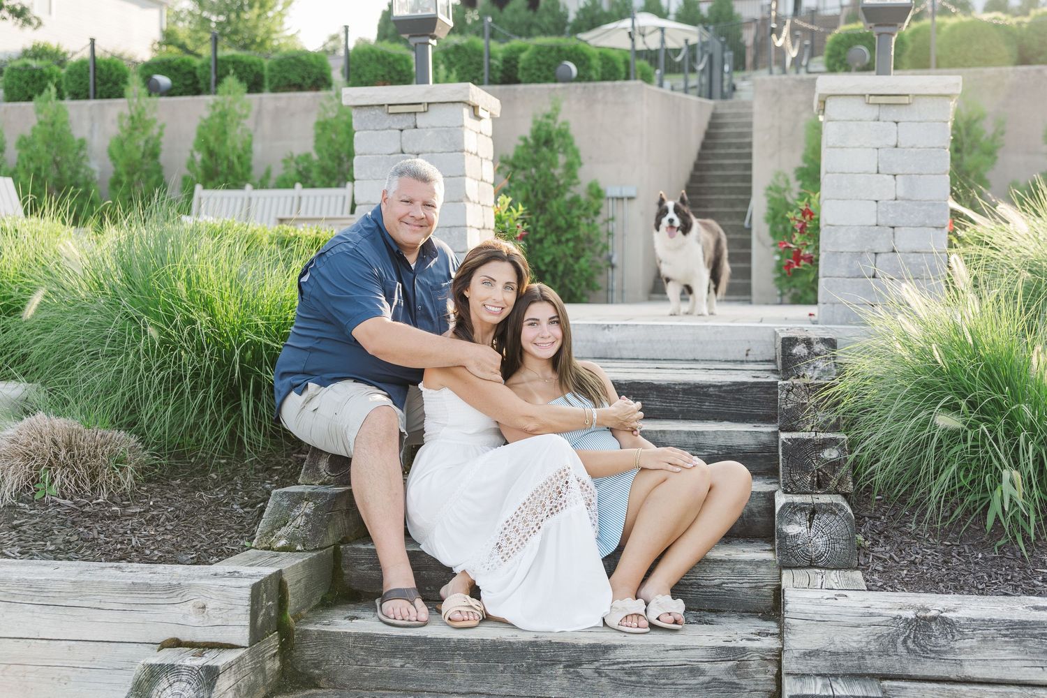 Family sitting by stone steps during Pistakee Lake family photos in Johnsburg, Illinois