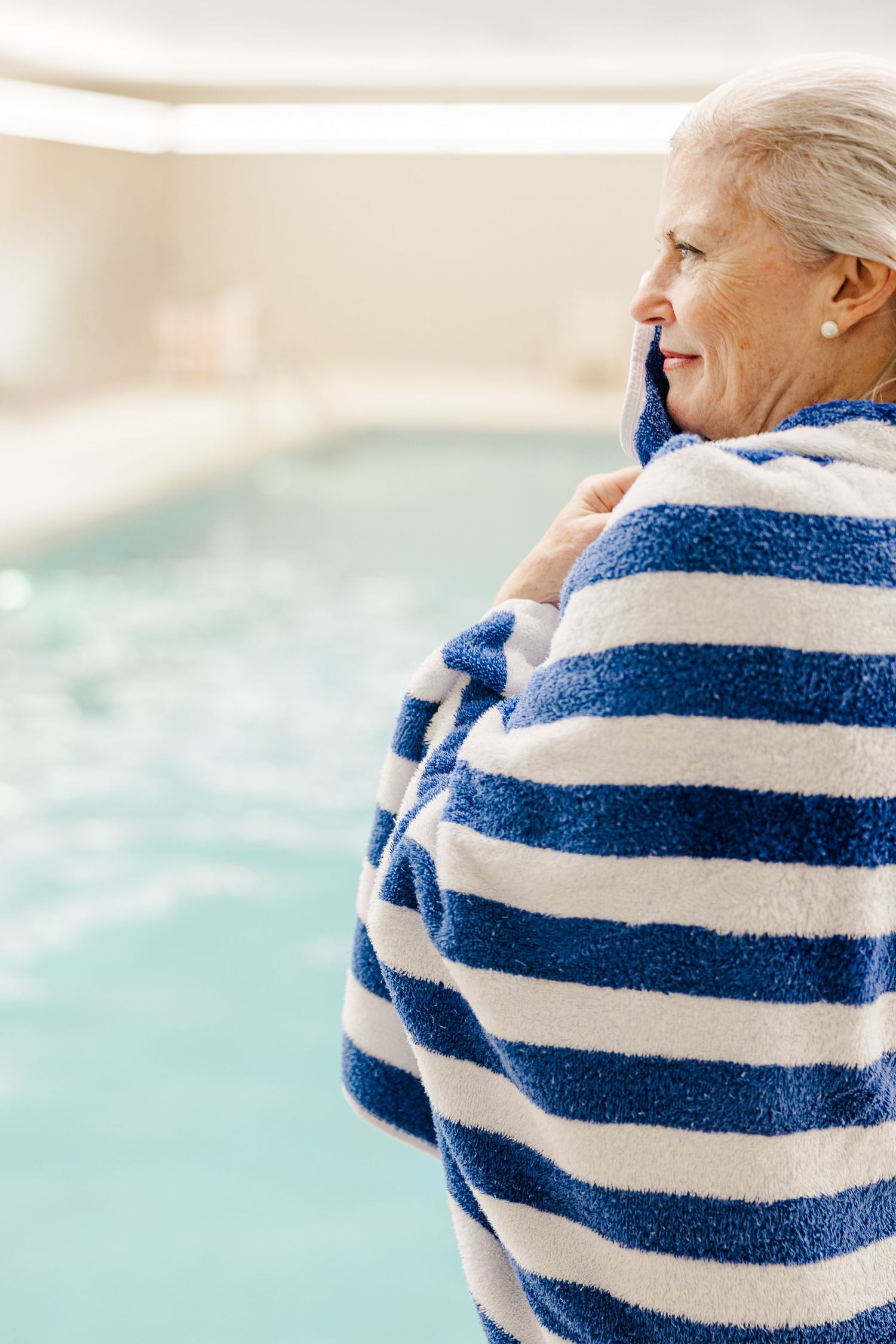 Beacon Hill senior living branding photo in Lombard, Illinois featuring resident wrapped in striped towel by pool