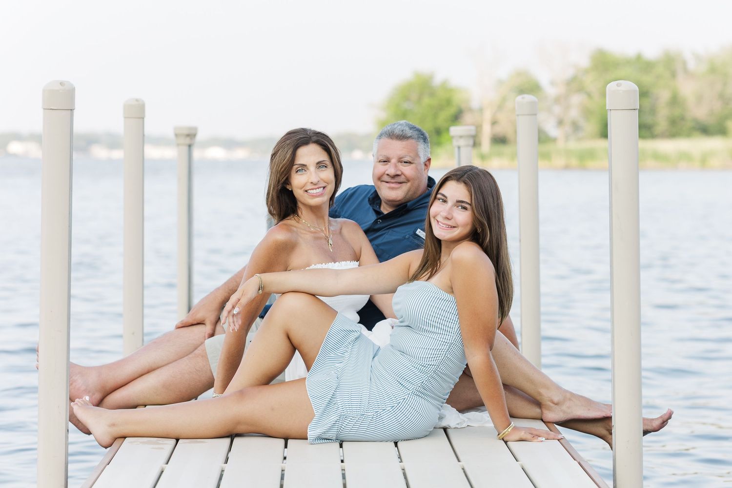 Family sitting together on dock during Pistakee Lake family photos in Johnsburg, Illinois