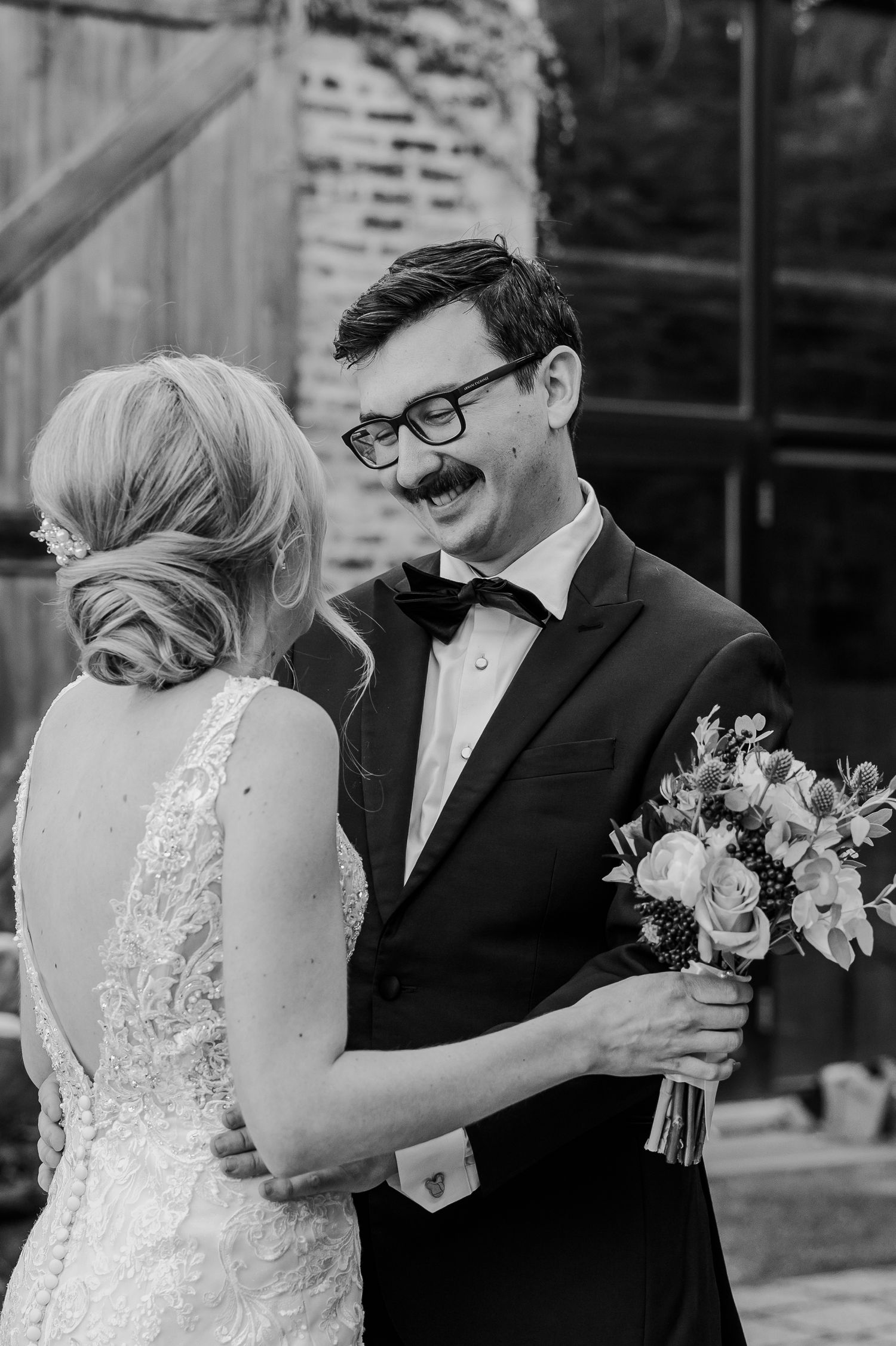Intimate wedding moment captured in black and white as couple shares floral bouquet.