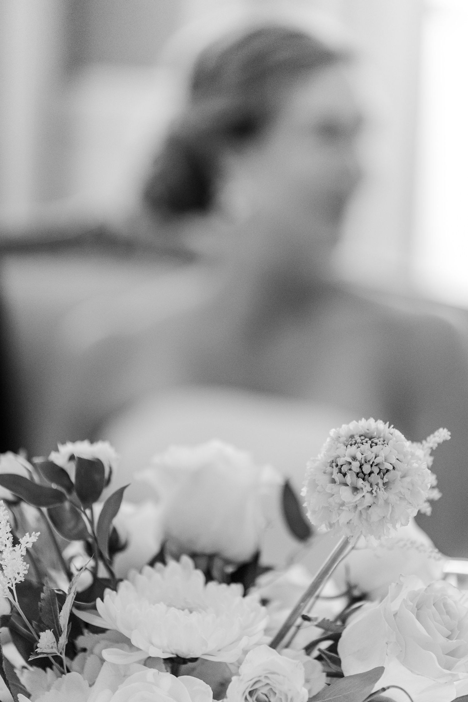 Black and white photo of flowers in foreground with soft focus background.