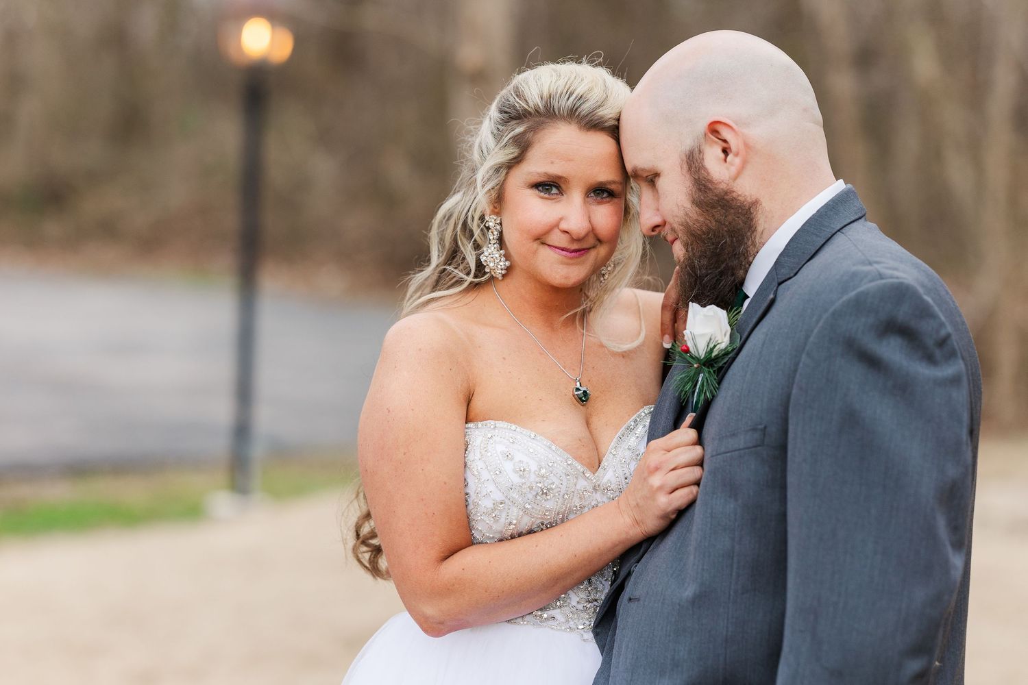 Romantic wedding portrait with soft lighting and vintage lamp post in background.