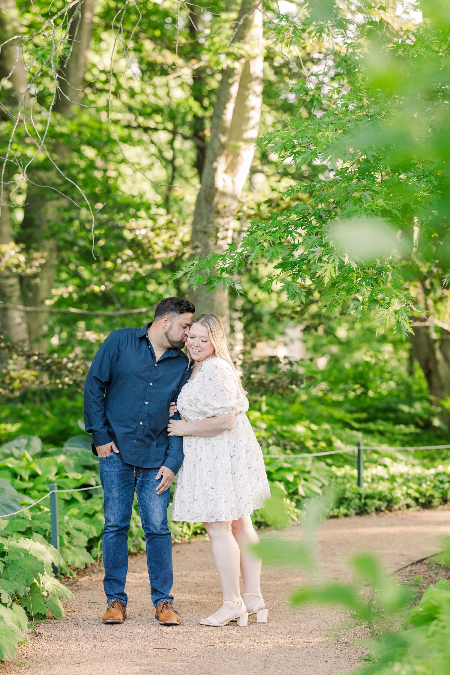 A romantic woodland photo session on a sunlit garden path.