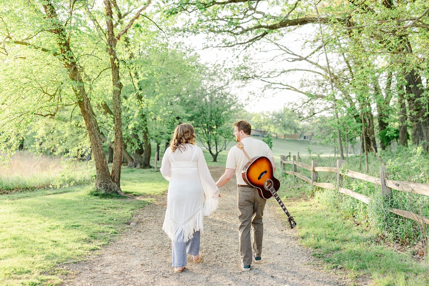 Expecting parents walking with guitar during a maternity session at Veterans Acres Nature Preserve.