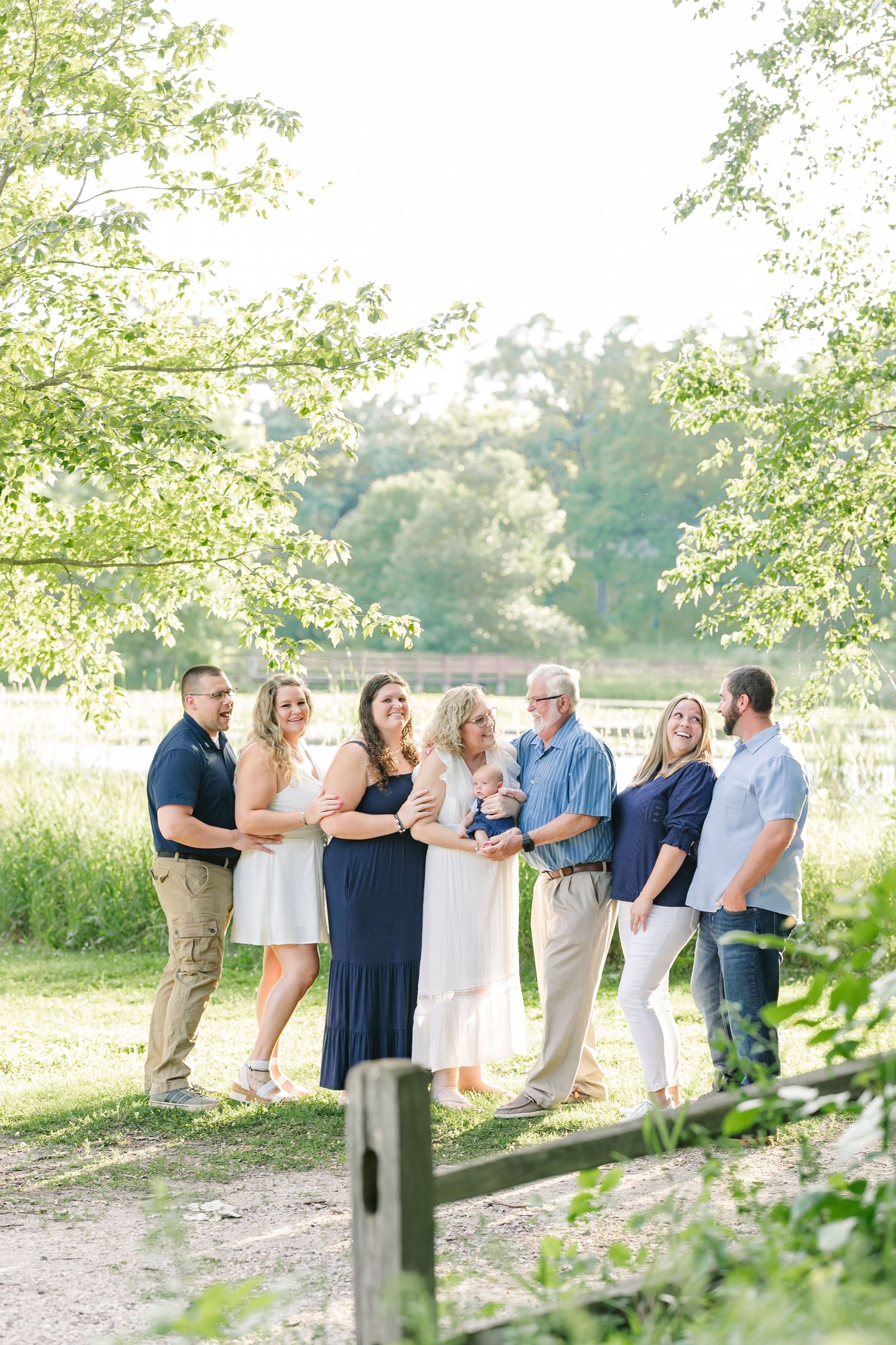 Extended family standing together on a wooded path for summer portraits at Veterans Acres Nature Center in Crystal Lake