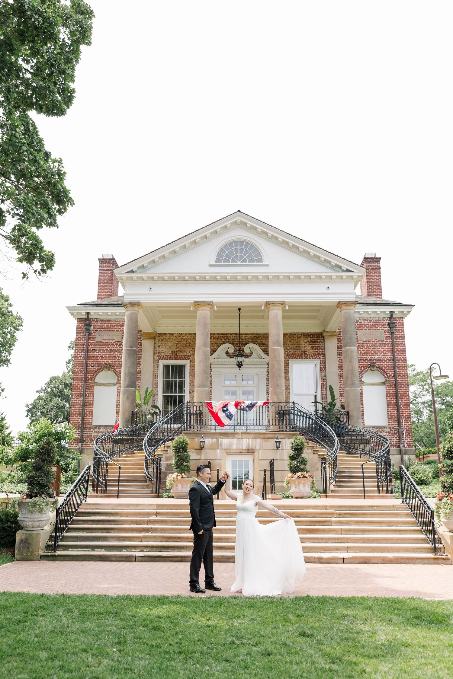 Monika and Rafael posing in front of the grand staircase and brick exterior of McCormick House.