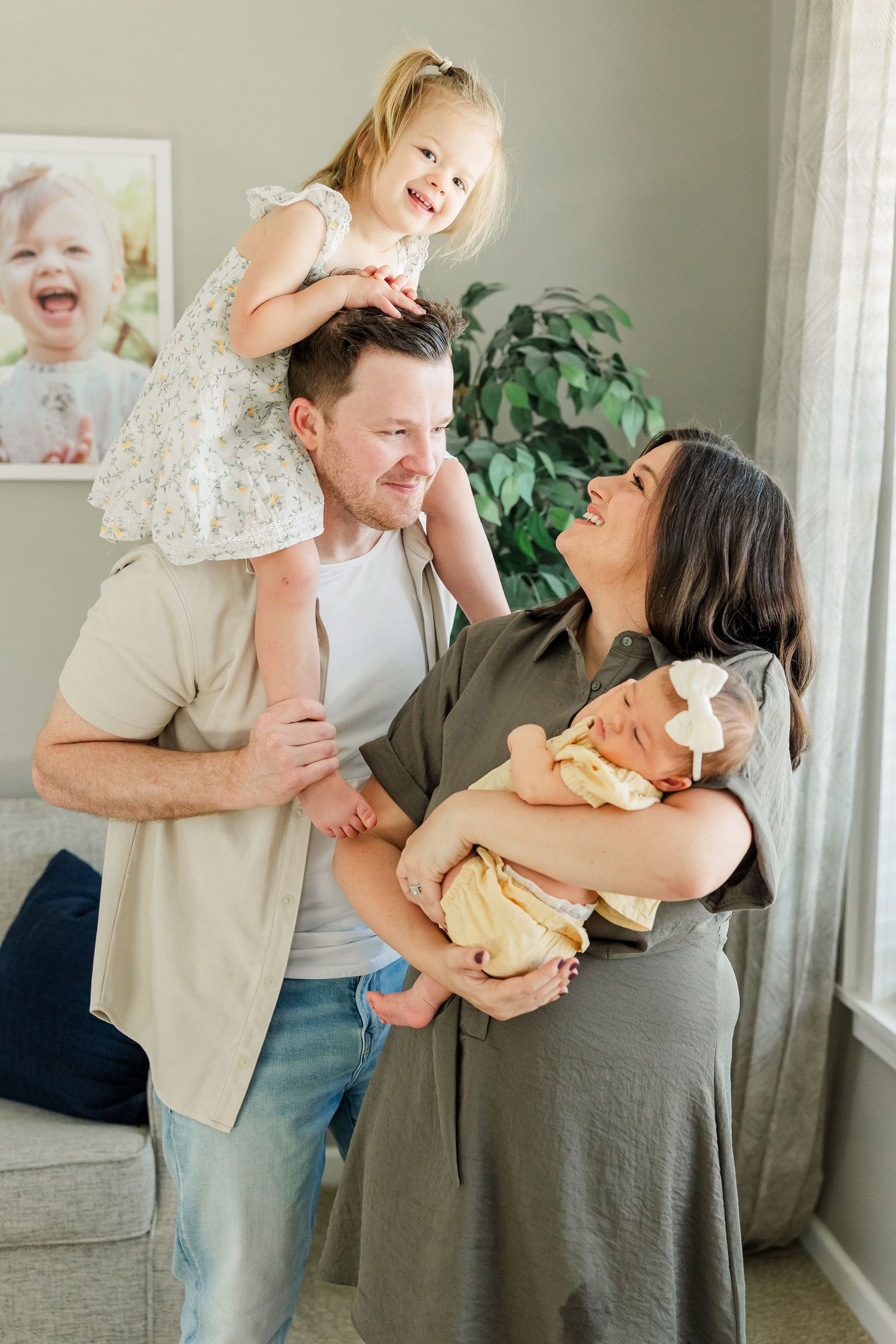 Lifestyle newborn photo of parents laughing with big sister and baby girl at home in Huntley IL