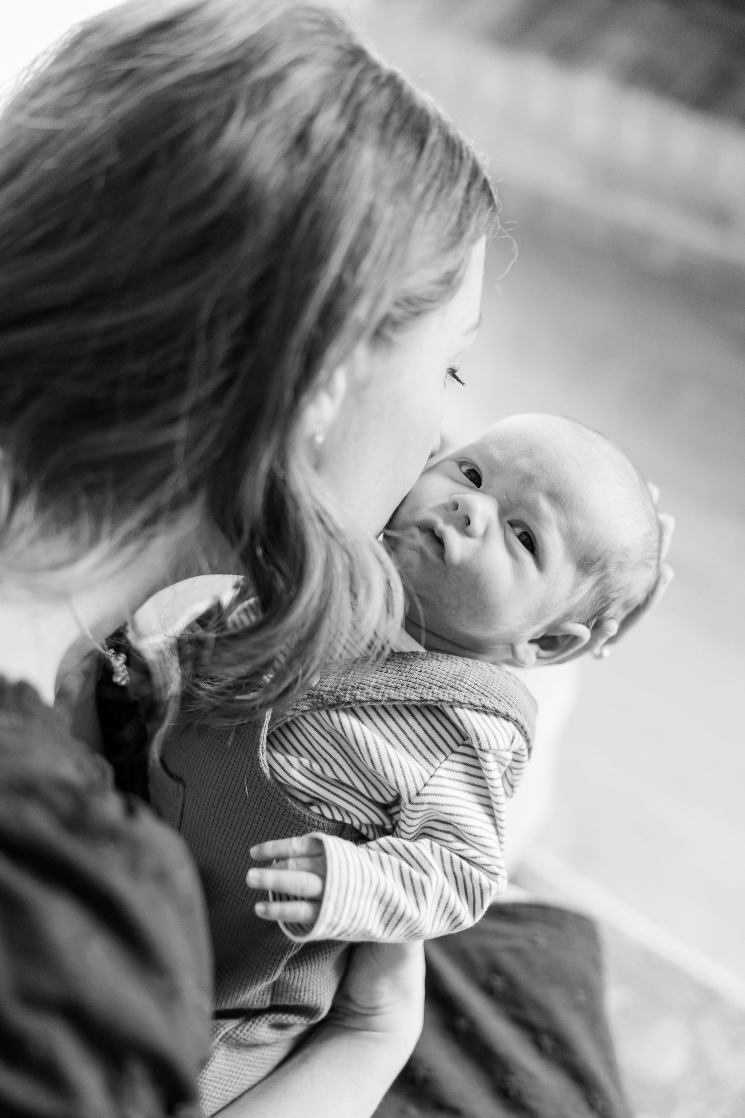 Mother holds newborn son in black and white portrait during Crystal Lake lifestyle newborn session