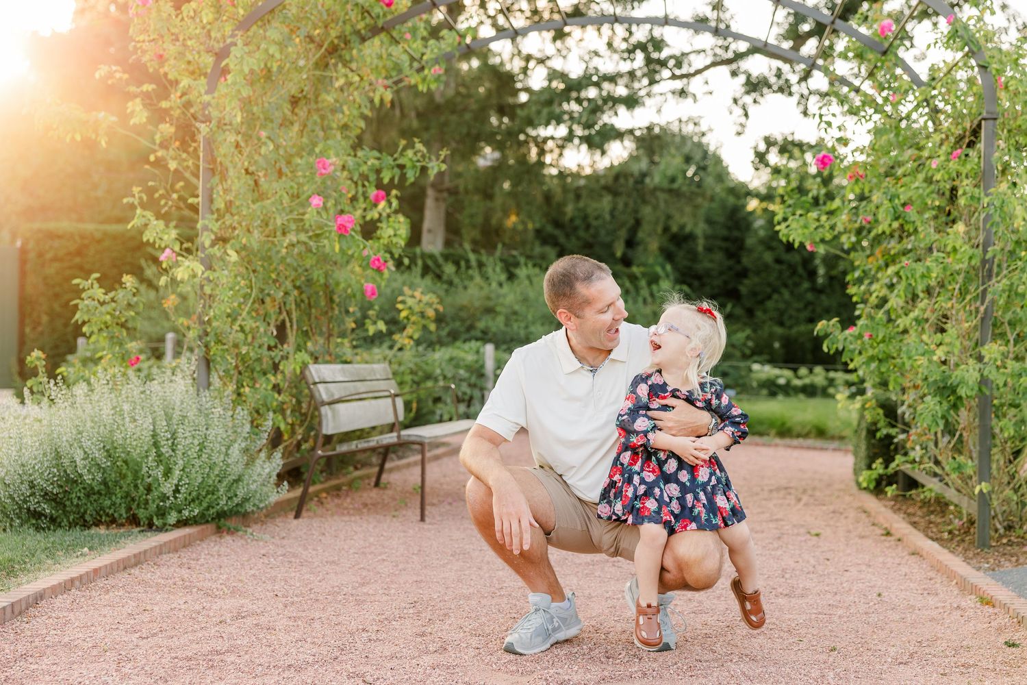 Andrew and Caroline laughing together in the warm evening light during light during their family session.