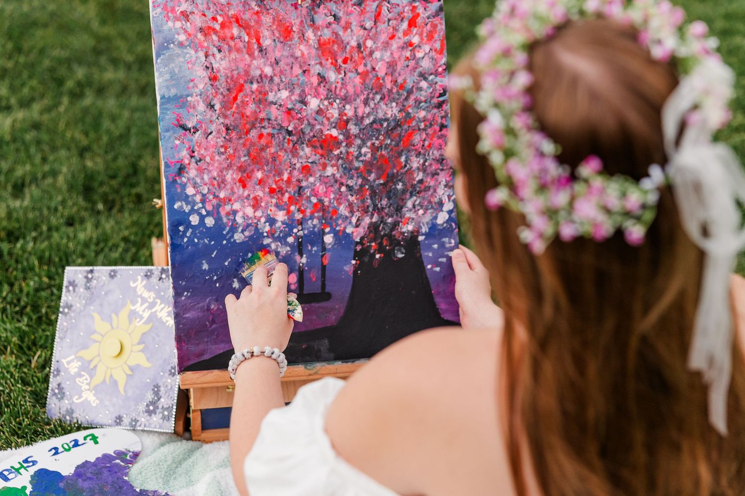 Samantha adds colorful paint to her canvas during her whimsical art-inspired senior portrait session.